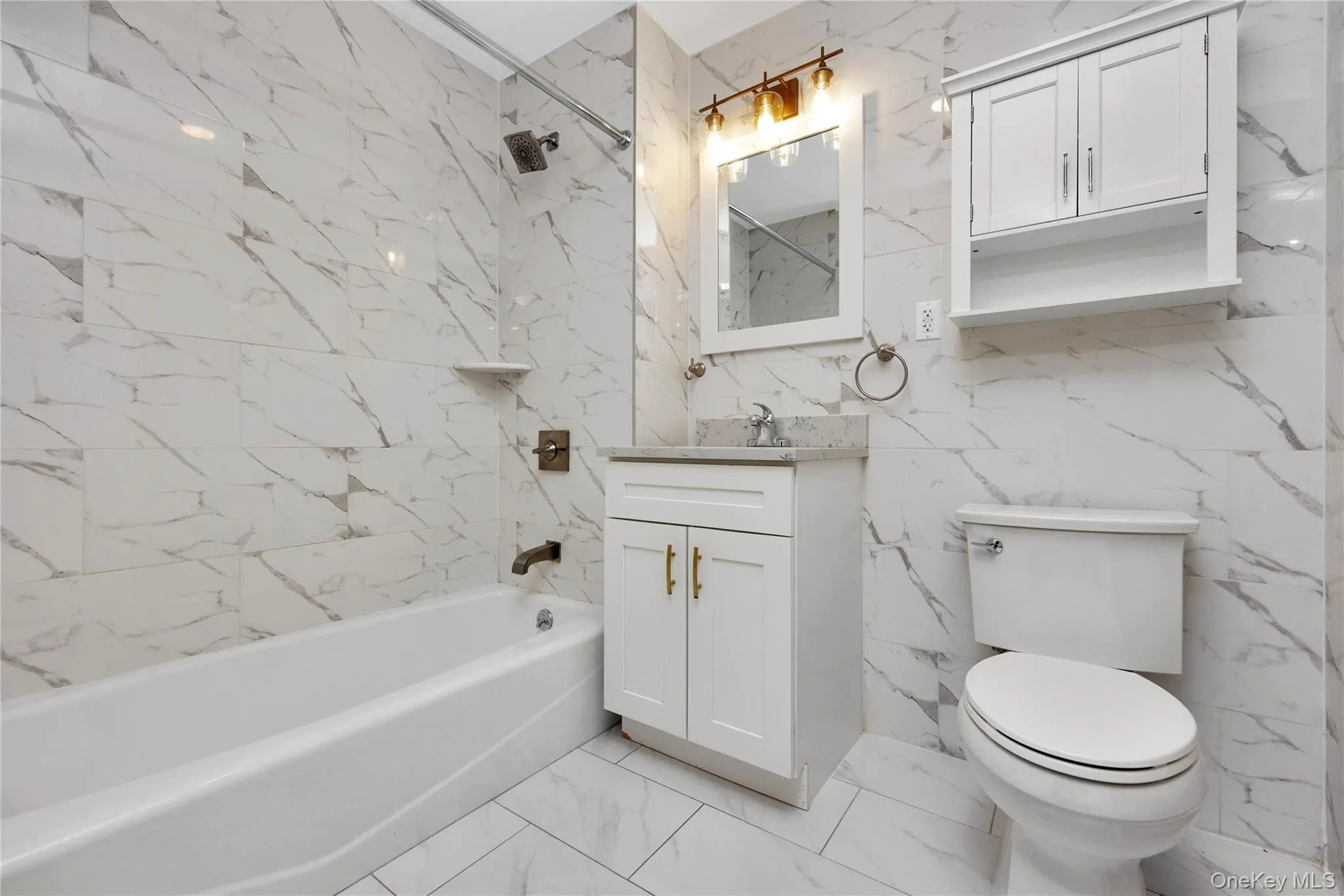 Full bath featuring toilet, vanity, marble finish floor, and shower / washtub combination Full bath featuring toilet, vanity, marble finish floor, and shower / washtub combination