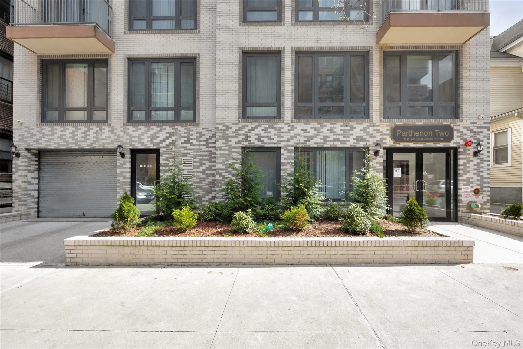 View of property featuring a garage, brick siding, and driveway View of property featuring a garage, brick siding, and driveway