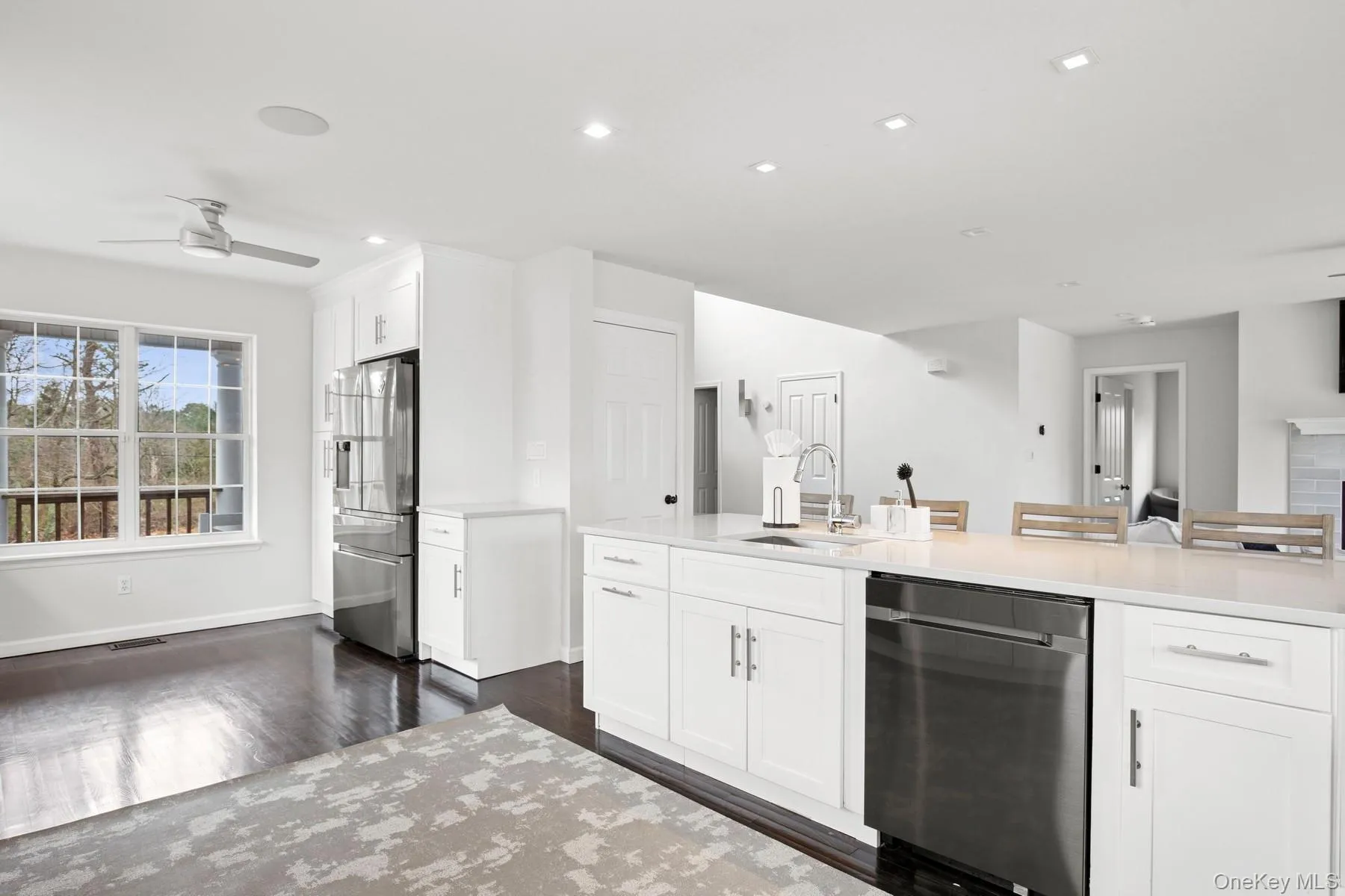 Kitchen featuring a sink, ceiling fan, dark wood-style floors, white cabinetry, and stainless steel appliances Kitchen featuring a sink, ceiling fan, dark wood-style floors, white cabinetry, and stainless steel appliances