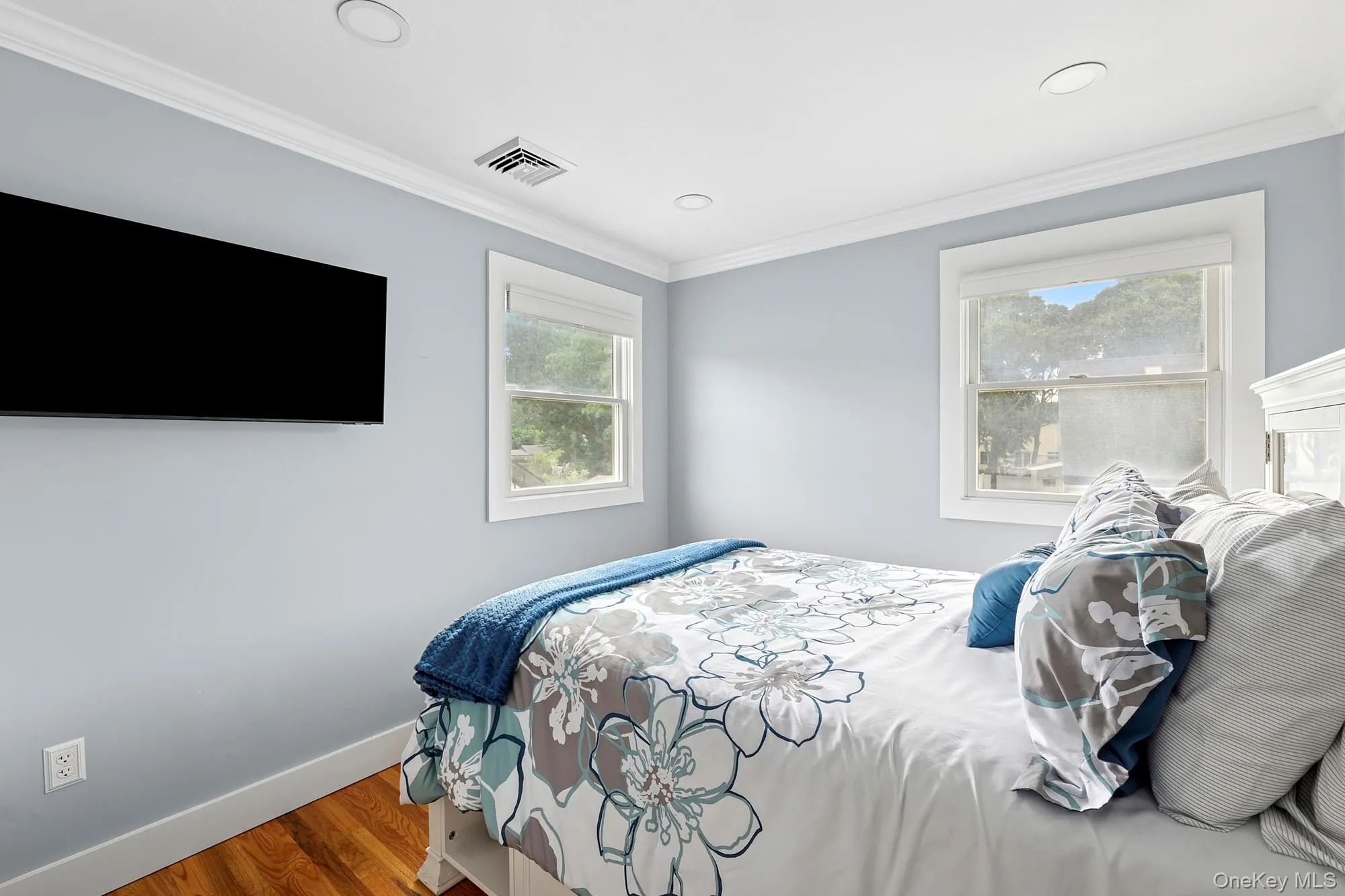 Bedroom with crown molding, wood finished floors, and recessed lighting Bedroom with crown molding, wood finished floors, and recessed lighting