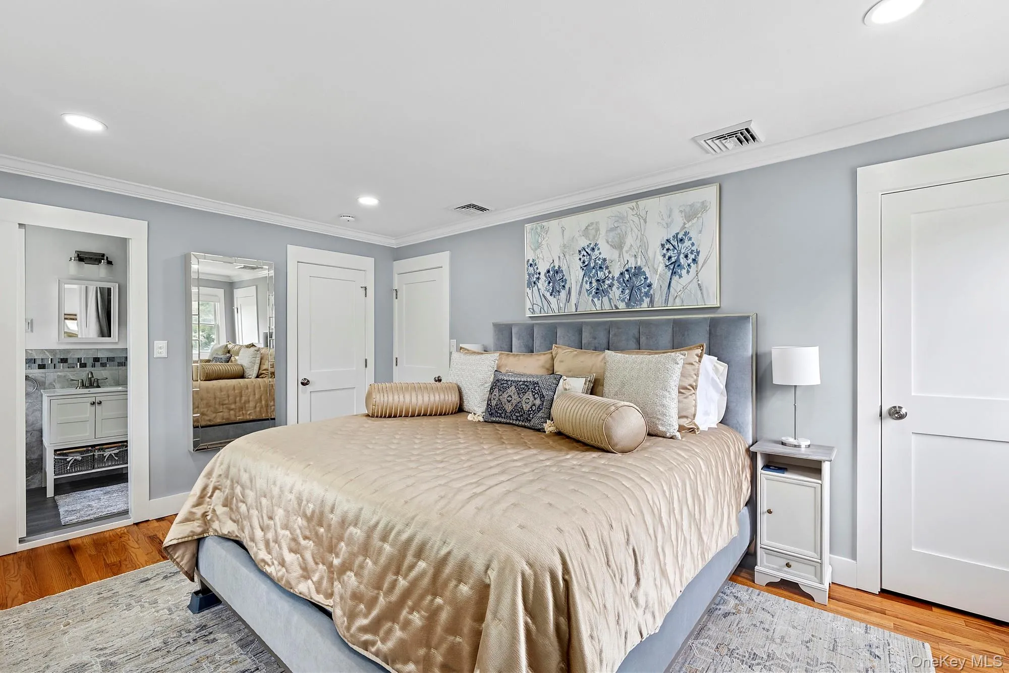 Primary bedroom featuring recessed lighting, light wood-type flooring, ornamental molding, and ensuite bathroom Primary bedroom featuring recessed lighting, light wood-type flooring, ornamental molding, and ensuite bathroom