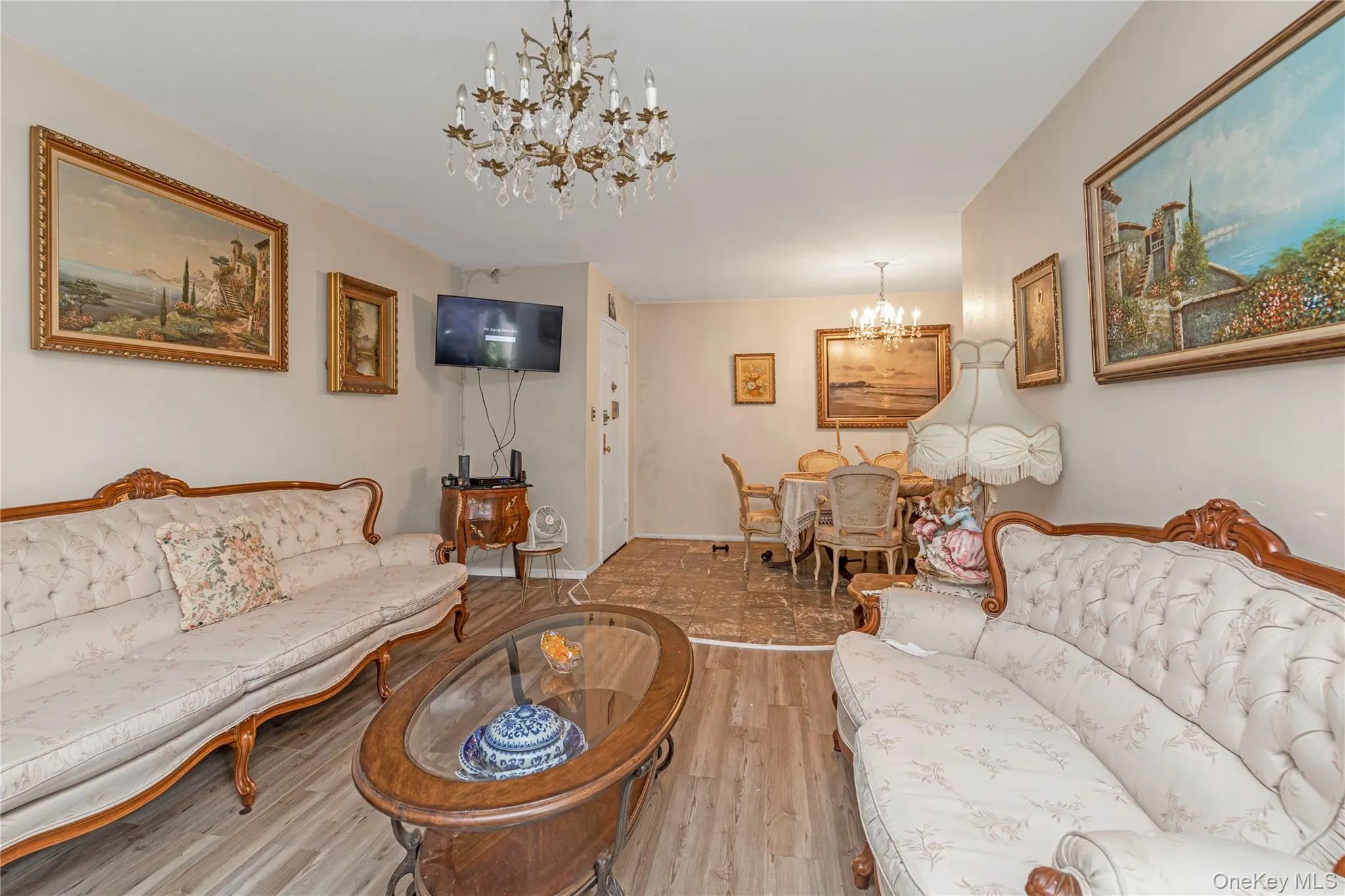 Living room featuring a chandelier and wood finished floors Living room featuring a chandelier and wood finished floors
