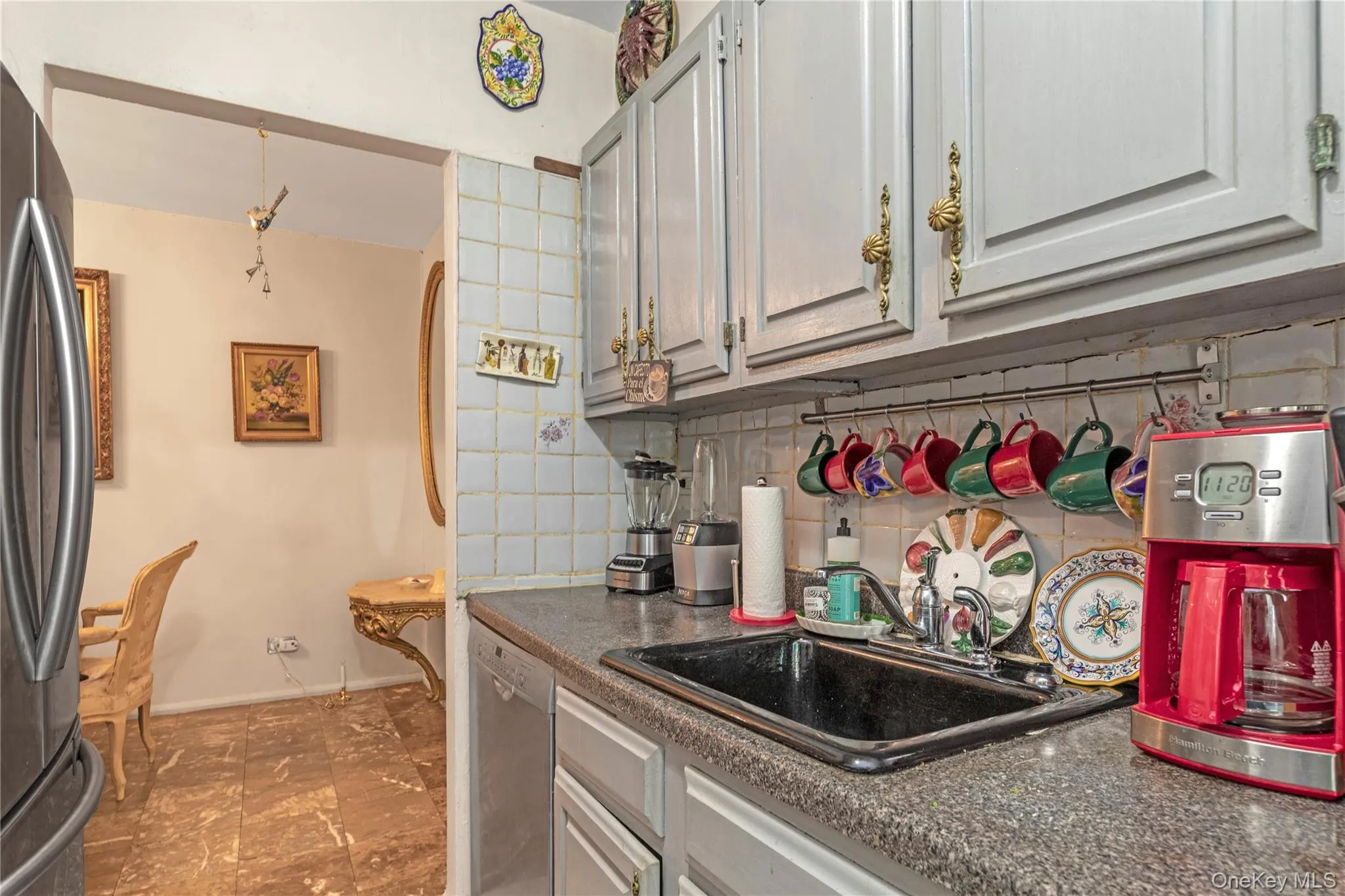 Kitchen featuring backsplash, appliances with stainless steel finishes, and dark countertops Kitchen featuring backsplash, appliances with stainless steel finishes, and dark countertops