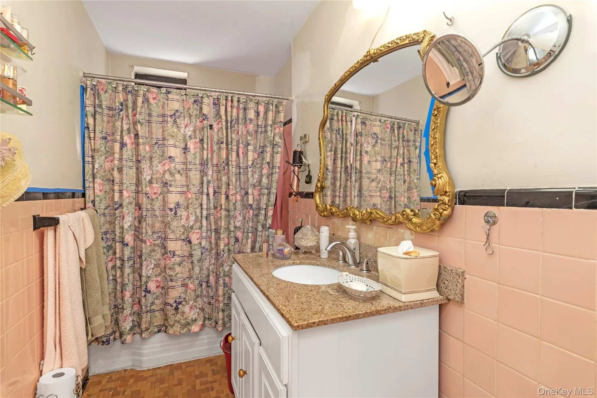 Bathroom featuring tile walls, wainscoting, vanity, and a shower with shower curtain Bathroom featuring tile walls, wainscoting, vanity, and a shower with shower curtain
