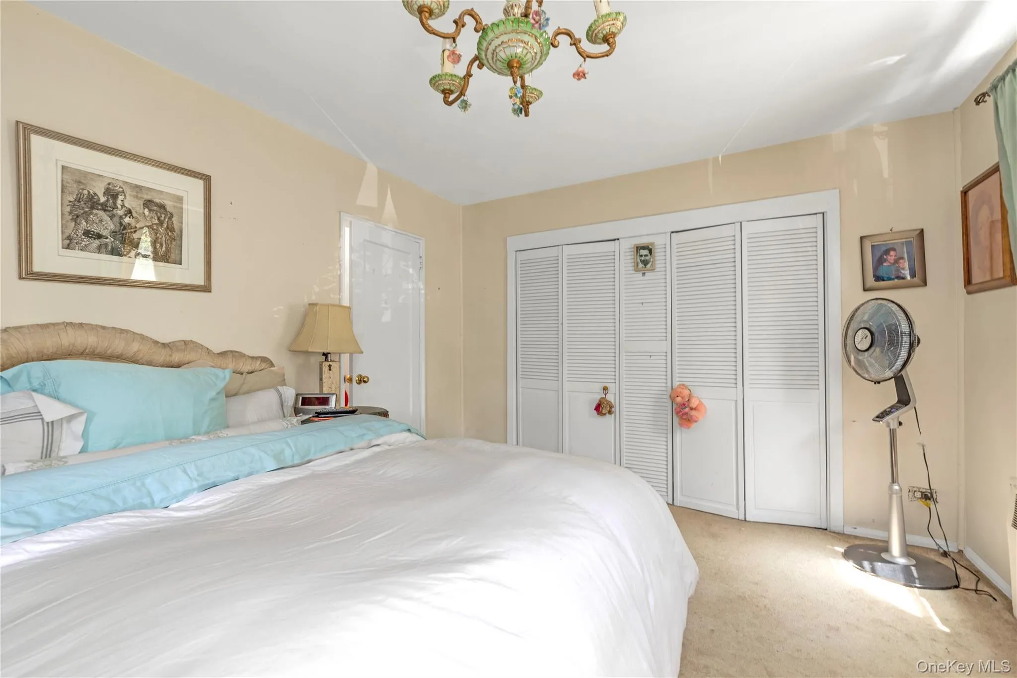 Bedroom featuring light colored carpet, a closet, and a chandelier Bedroom featuring light colored carpet, a closet, and a chandelier