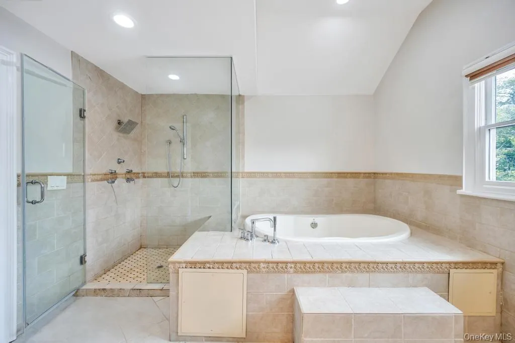 Full bath featuring recessed lighting, tile patterned flooring, a bath, and a stall shower Full bath featuring recessed lighting, tile patterned flooring, a bath, and a stall shower