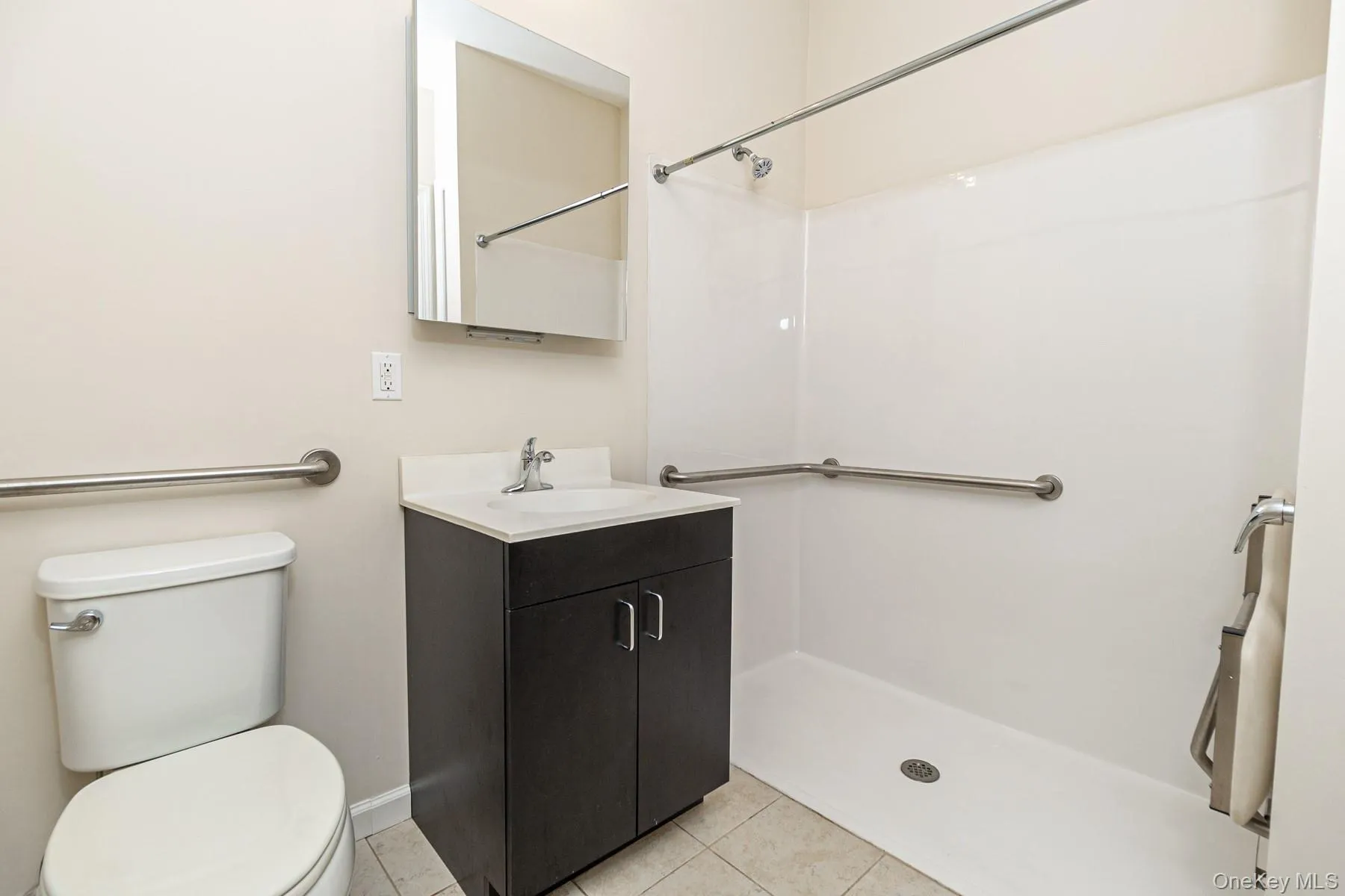 Bathroom with toilet, tile patterned floors, vanity, and walk in shower Bathroom with toilet, tile patterned floors, vanity, and walk in shower