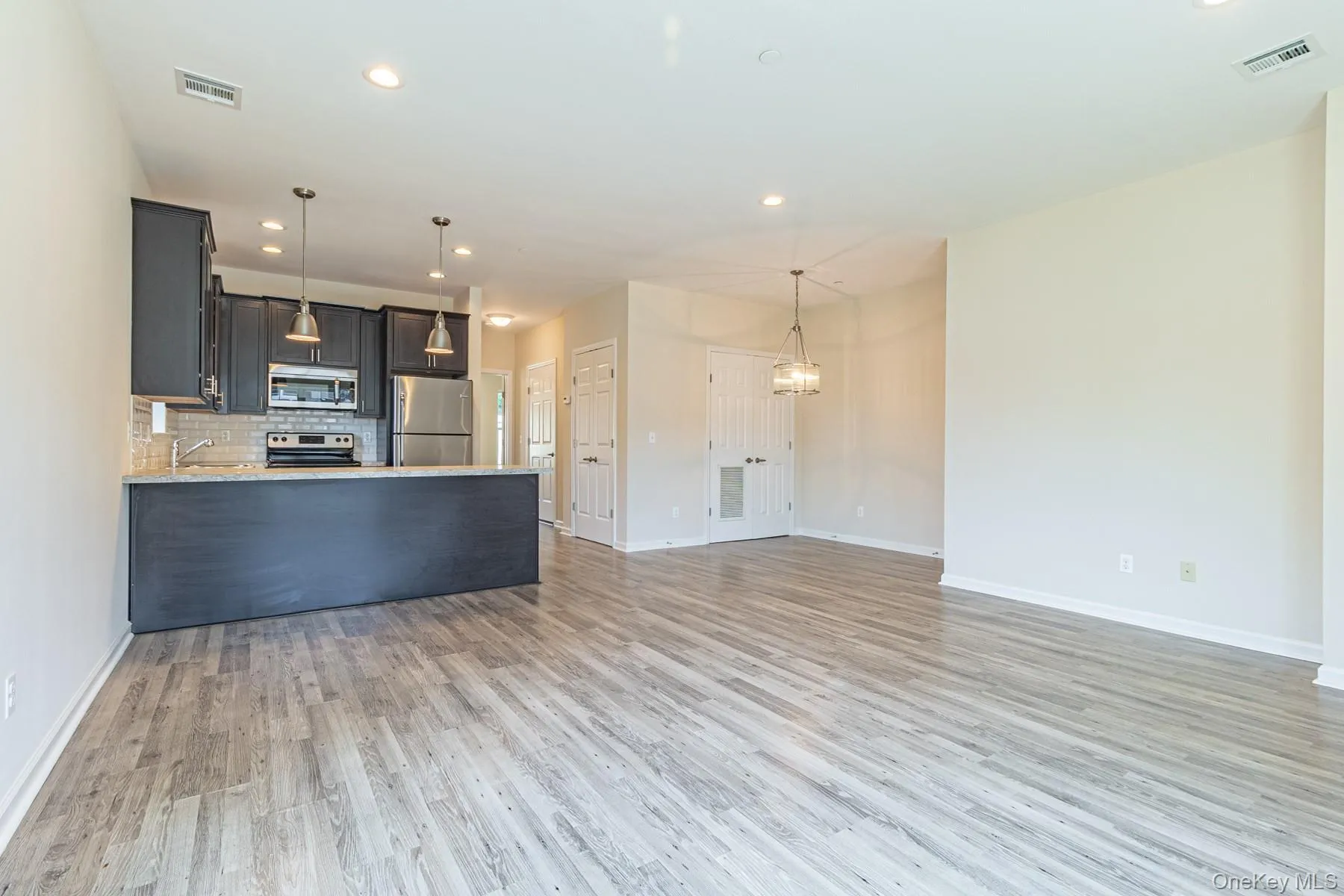Kitchen with tasteful backsplash, a peninsula, visible vents, and stainless steel appliances Kitchen with tasteful backsplash, a peninsula, visible vents, and stainless steel appliances