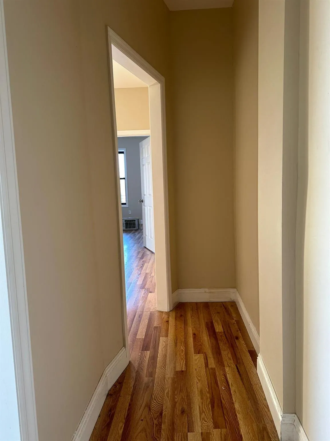 Hall with baseboards and wood finished floors Hall with baseboards and wood finished floors