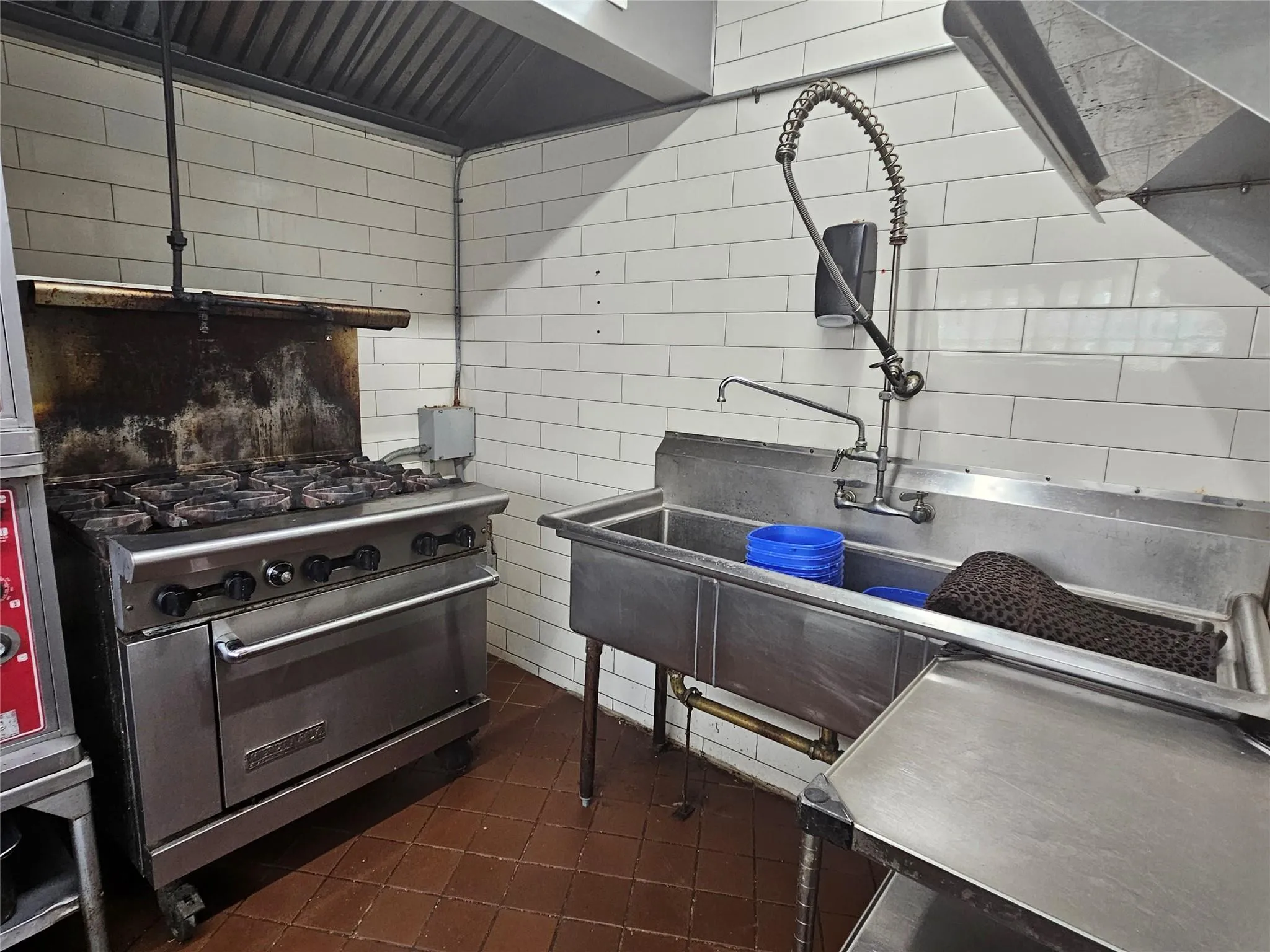 Kitchen featuring tile walls, dark tile patterned floors, and high end stainless steel range oven Kitchen featuring tile walls, dark tile patterned floors, and high end stainless steel range oven