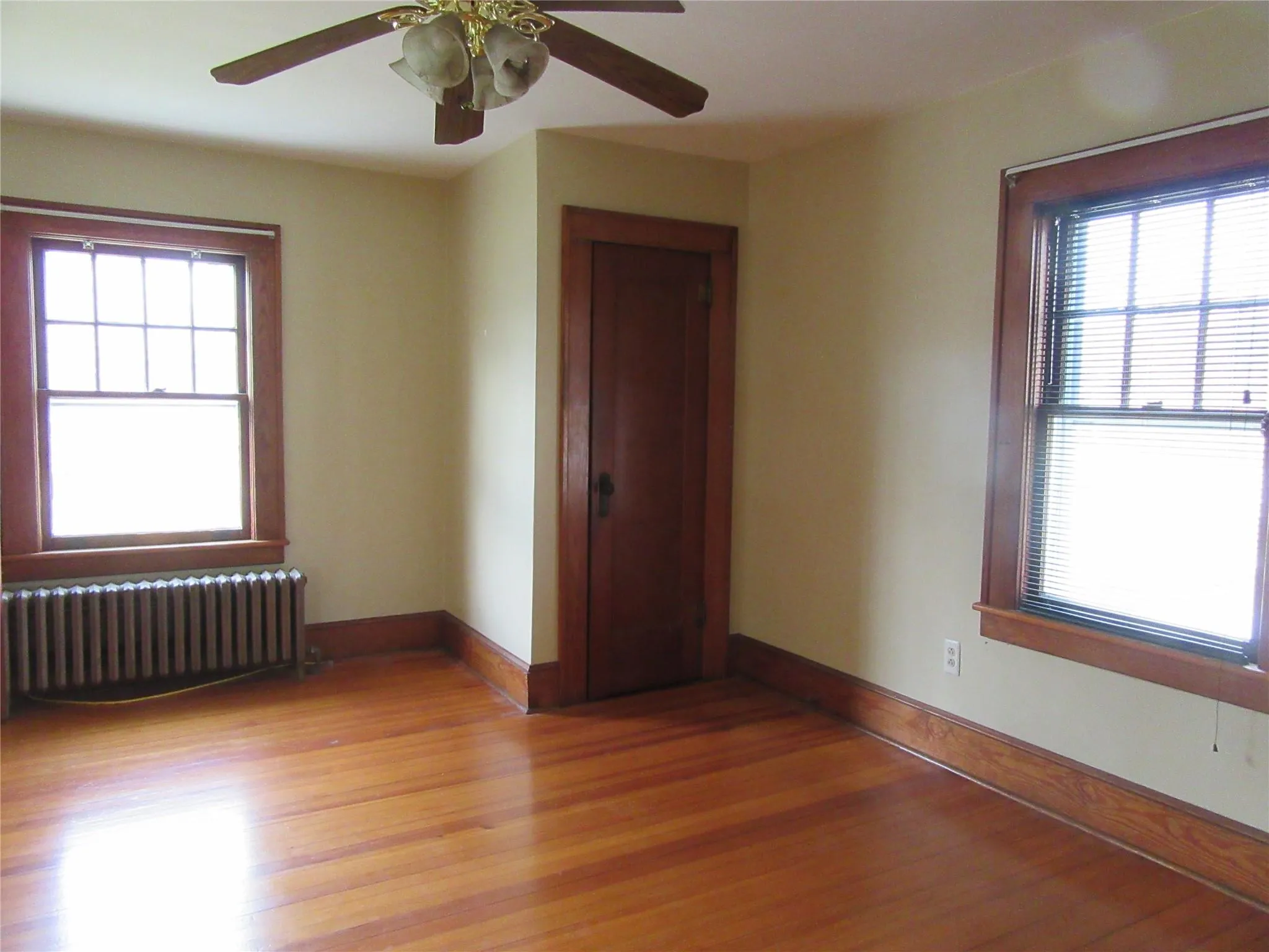 Spare room with light wood-style flooring, radiator heating unit, and baseboards Spare room with light wood-style flooring, radiator heating unit, and baseboards