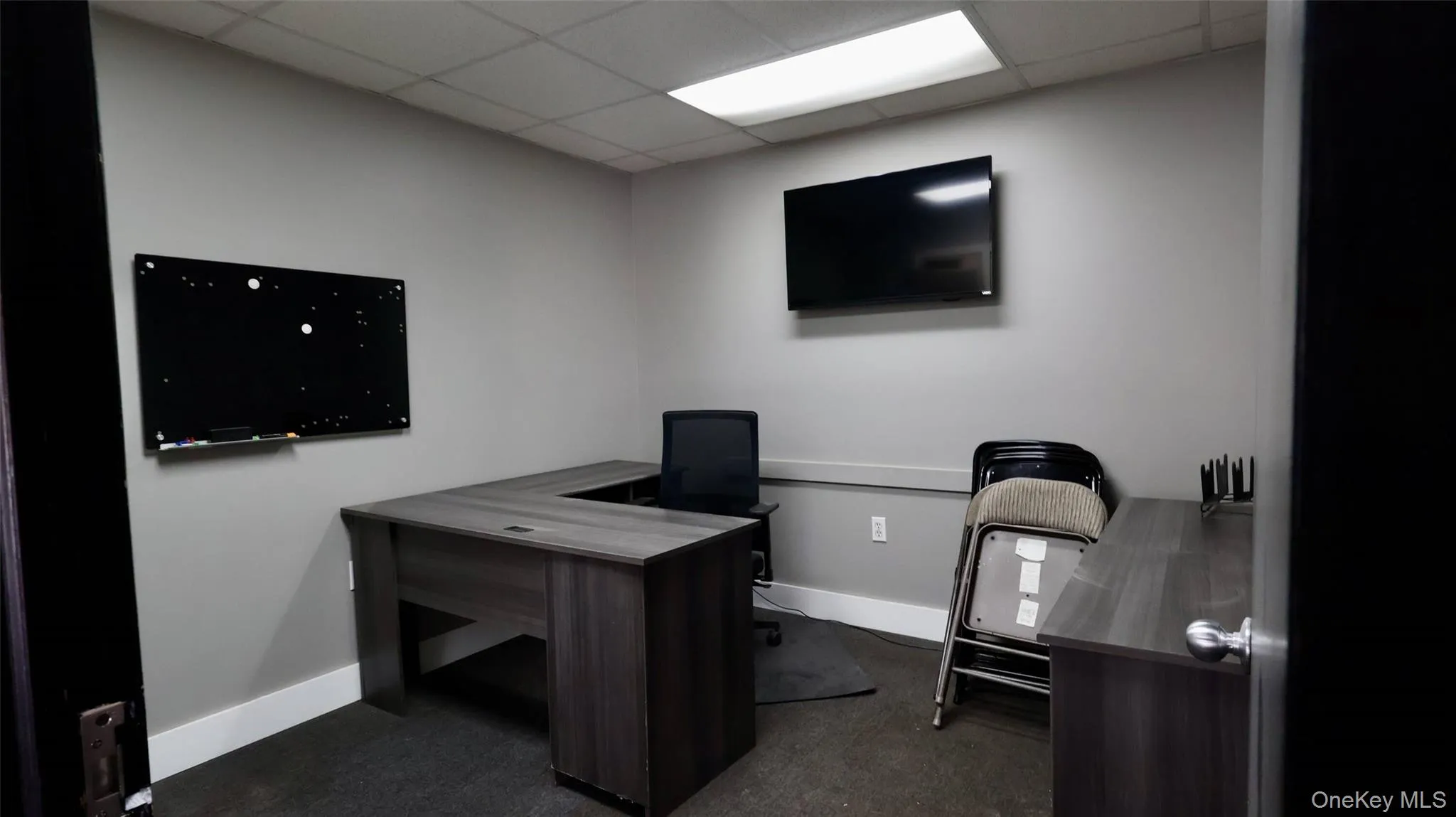 Office with dark carpet, baseboards, and a drop ceiling Office with dark carpet, baseboards, and a drop ceiling