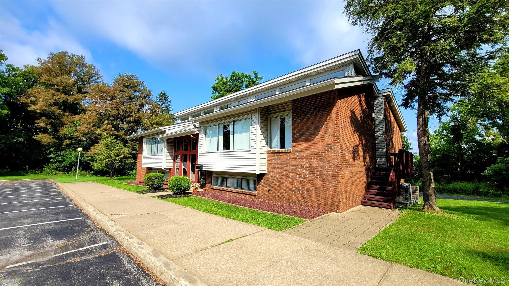 View of front of home featuring a front yard, brick siding, and uncovered parking View of front of home featuring a front yard, brick siding, and uncovered parking