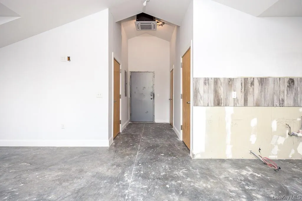 Hallway featuring visible vents, baseboards, and vaulted ceiling Hallway featuring visible vents, baseboards, and vaulted ceiling