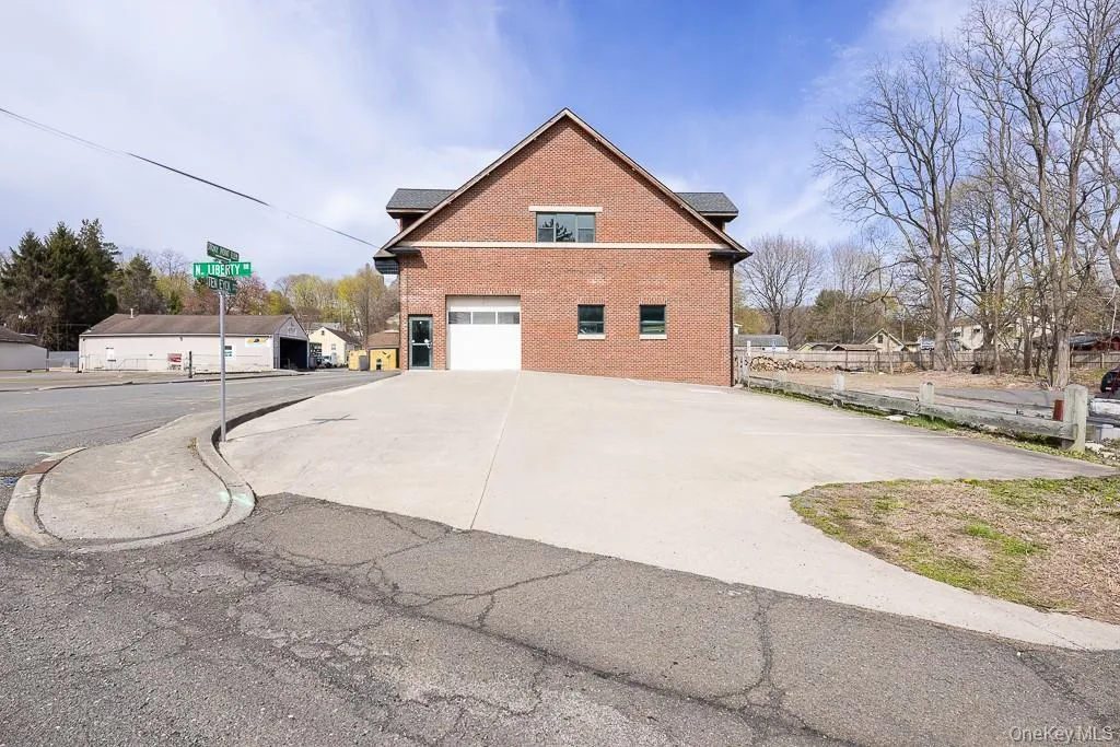 View of side of property featuring brick siding, an attached garage, and driveway View of side of property featuring brick siding, an attached garage, and driveway