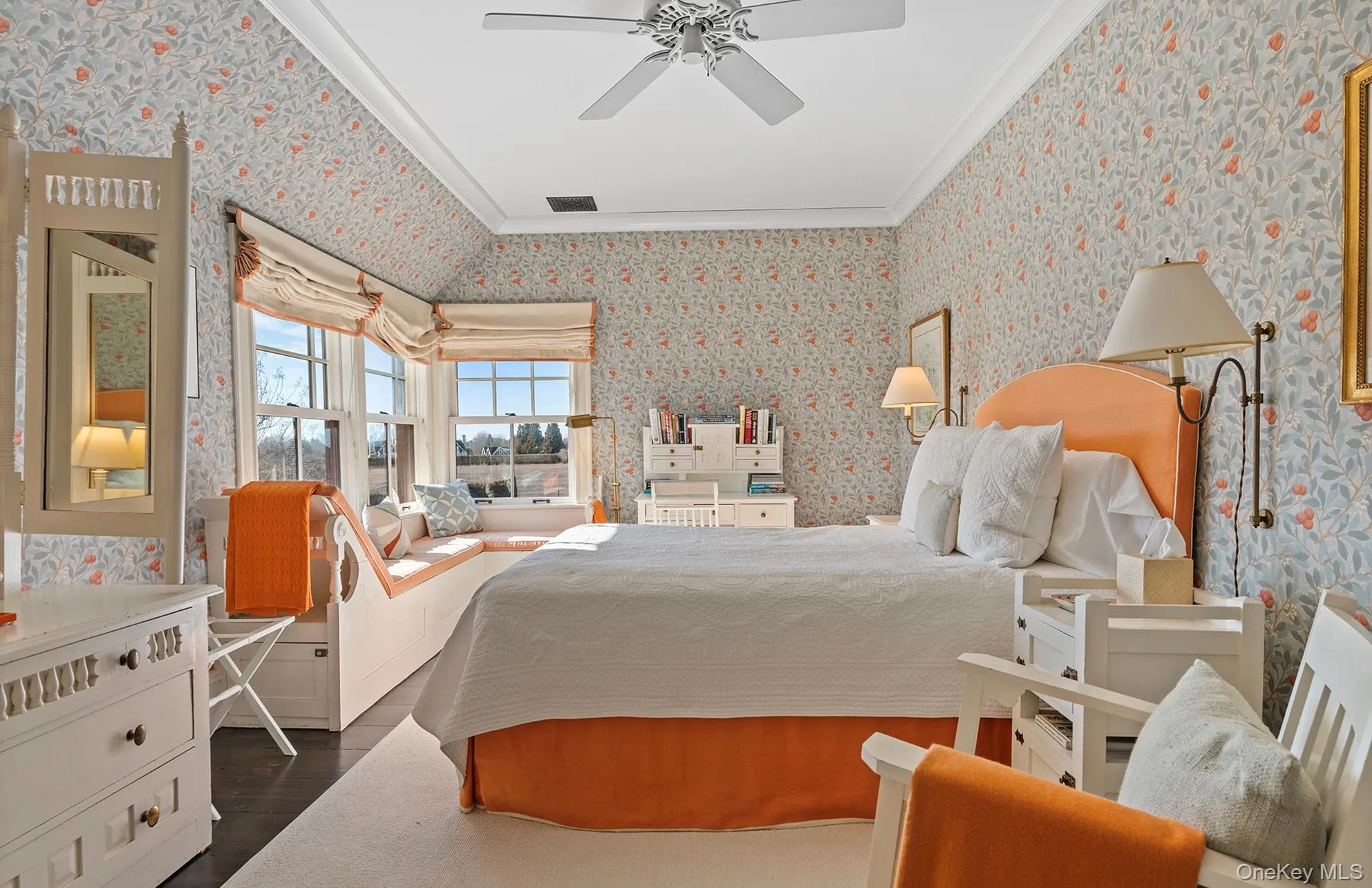 Bedroom featuring visible vents, ornamental molding, a ceiling fan, dark wood finished floors, and wallpapered walls Bedroom featuring visible vents, ornamental molding, a ceiling fan, dark wood finished floors, and wallpapered walls