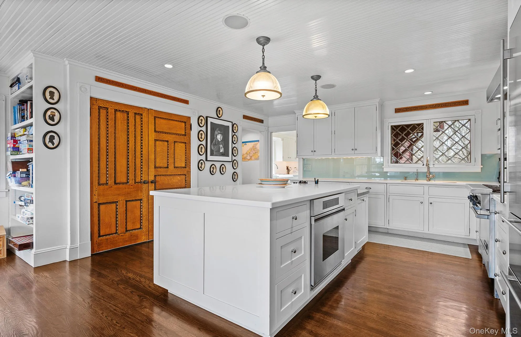 Kitchen featuring white cabinets, light countertops, ornamental molding, and stainless steel oven Kitchen featuring white cabinets, light countertops, ornamental molding, and stainless steel oven