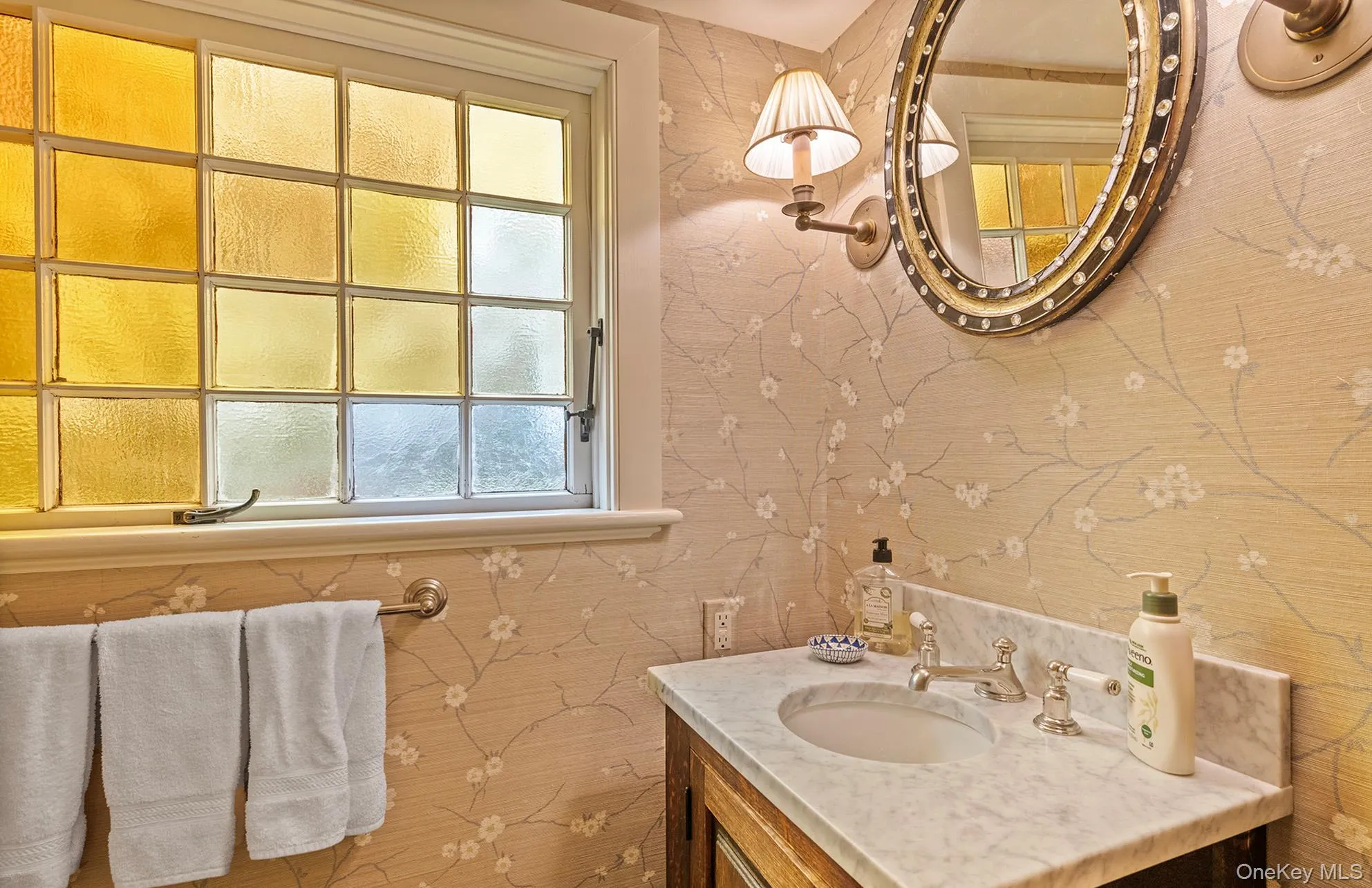 Bathroom featuring vanity and wallpapered walls Bathroom featuring vanity and wallpapered walls