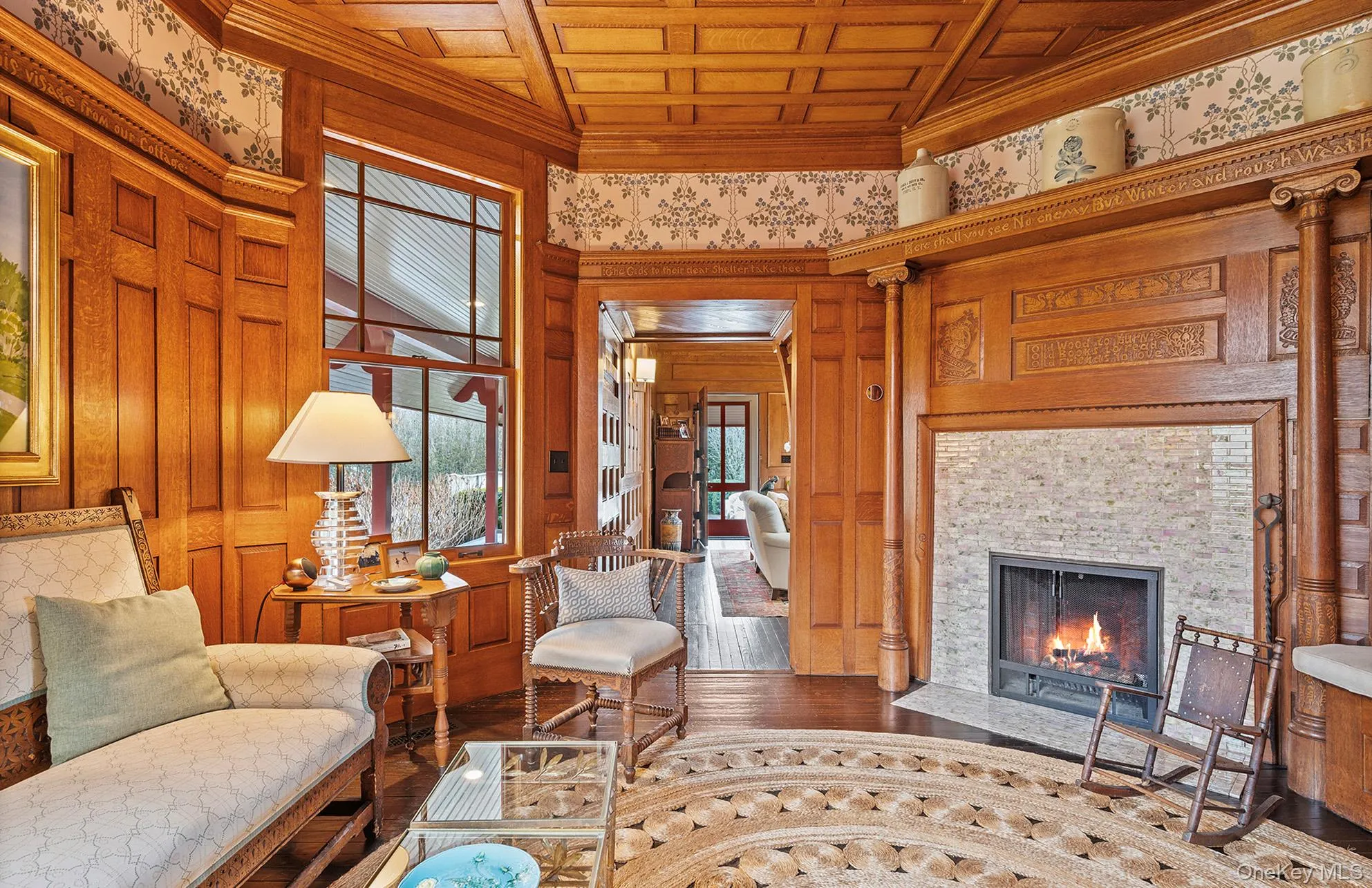 Living area with wooden ceiling, wood finished floors, ornamental molding, and a tile fireplace Living area with wooden ceiling, wood finished floors, ornamental molding, and a tile fireplace