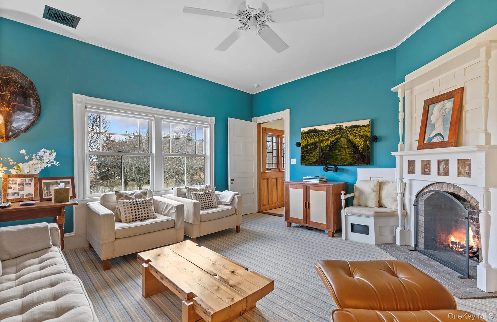 Living room featuring visible vents, a brick fireplace, a ceiling fan, carpet, and crown molding Living room featuring visible vents, a brick fireplace, a ceiling fan, carpet, and crown molding