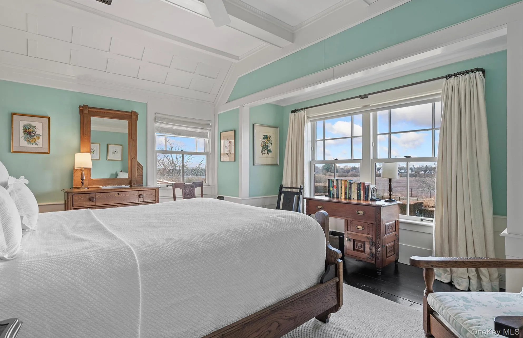 Bedroom with vaulted ceiling with beams, ornamental molding, and wood finished floors Bedroom with vaulted ceiling with beams, ornamental molding, and wood finished floors