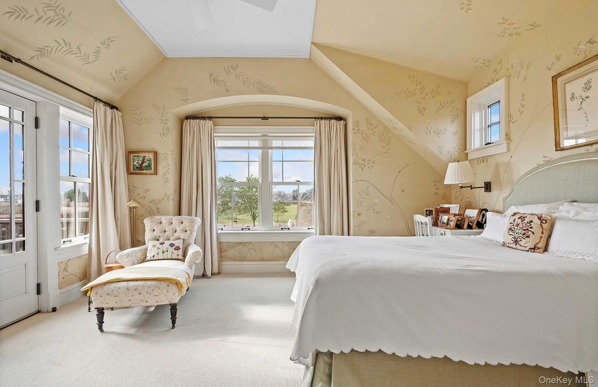 Carpeted bedroom featuring baseboards, ceiling fan, vaulted ceiling, and wallpapered walls Carpeted bedroom featuring baseboards, ceiling fan, vaulted ceiling, and wallpapered walls