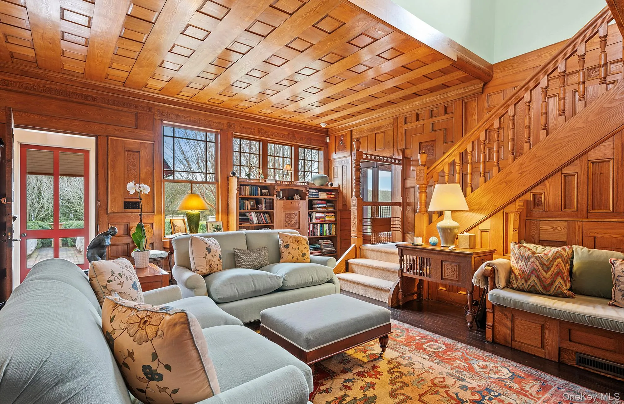 Living area featuring crown molding, wood walls, wood finished floors, and stairs Living area featuring crown molding, wood walls, wood finished floors, and stairs