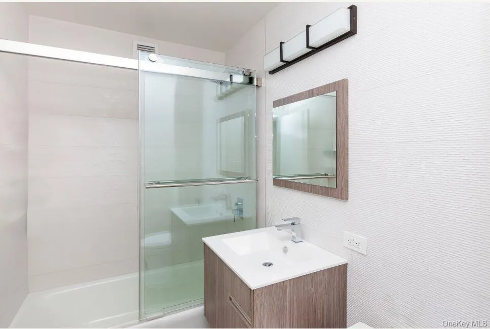 Bathroom featuring a stall shower and vanity Bathroom featuring a stall shower and vanity