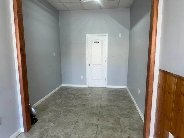 Unfurnished room featuring baseboards and a drop ceiling Unfurnished room featuring baseboards and a drop ceiling