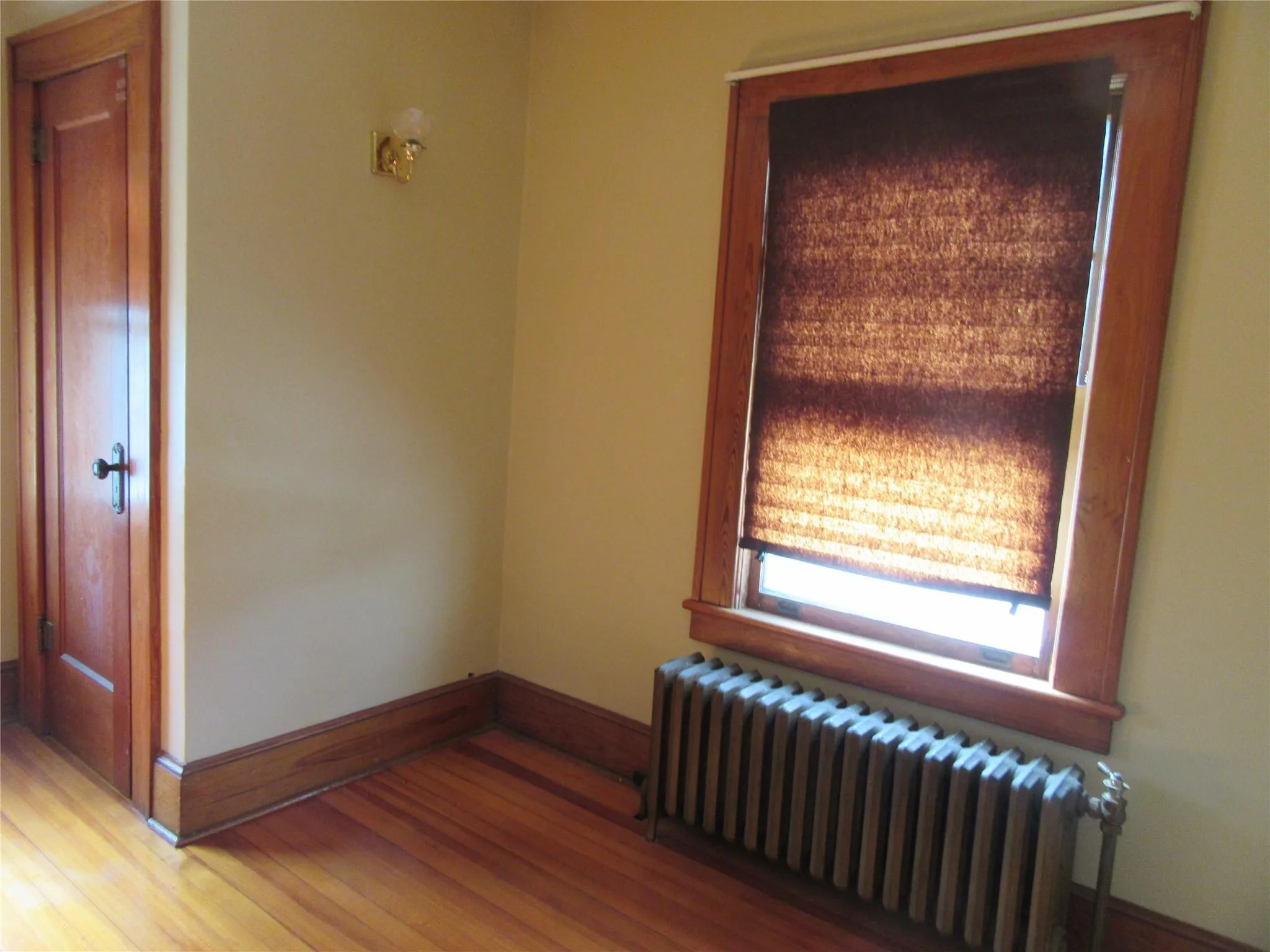 Unfurnished room with light wood-type flooring, baseboards, and radiator Unfurnished room with light wood-type flooring, baseboards, and radiator