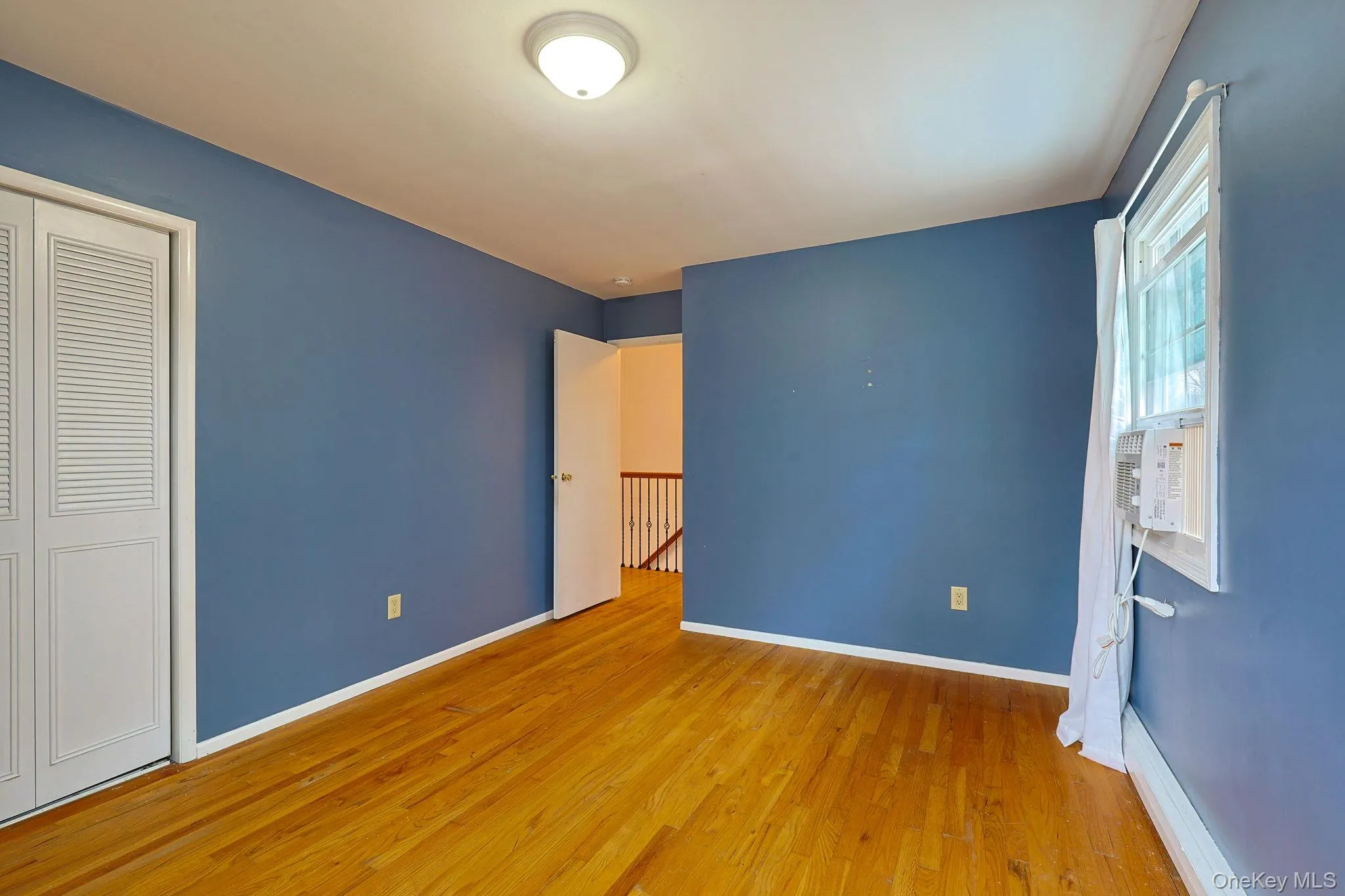 This room features hardwood floors and a ceiling light fixture This room features hardwood floors and a ceiling light fixture