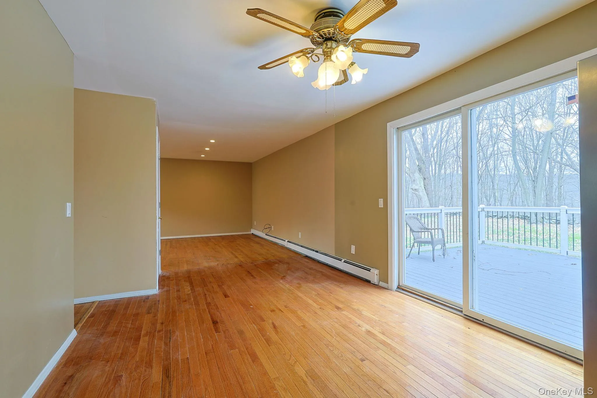 This room features hardwood floors, a ceiling fan with integrated lighting, and recessed ceiling lights This room features hardwood floors, a ceiling fan with integrated lighting, and recessed ceiling lights