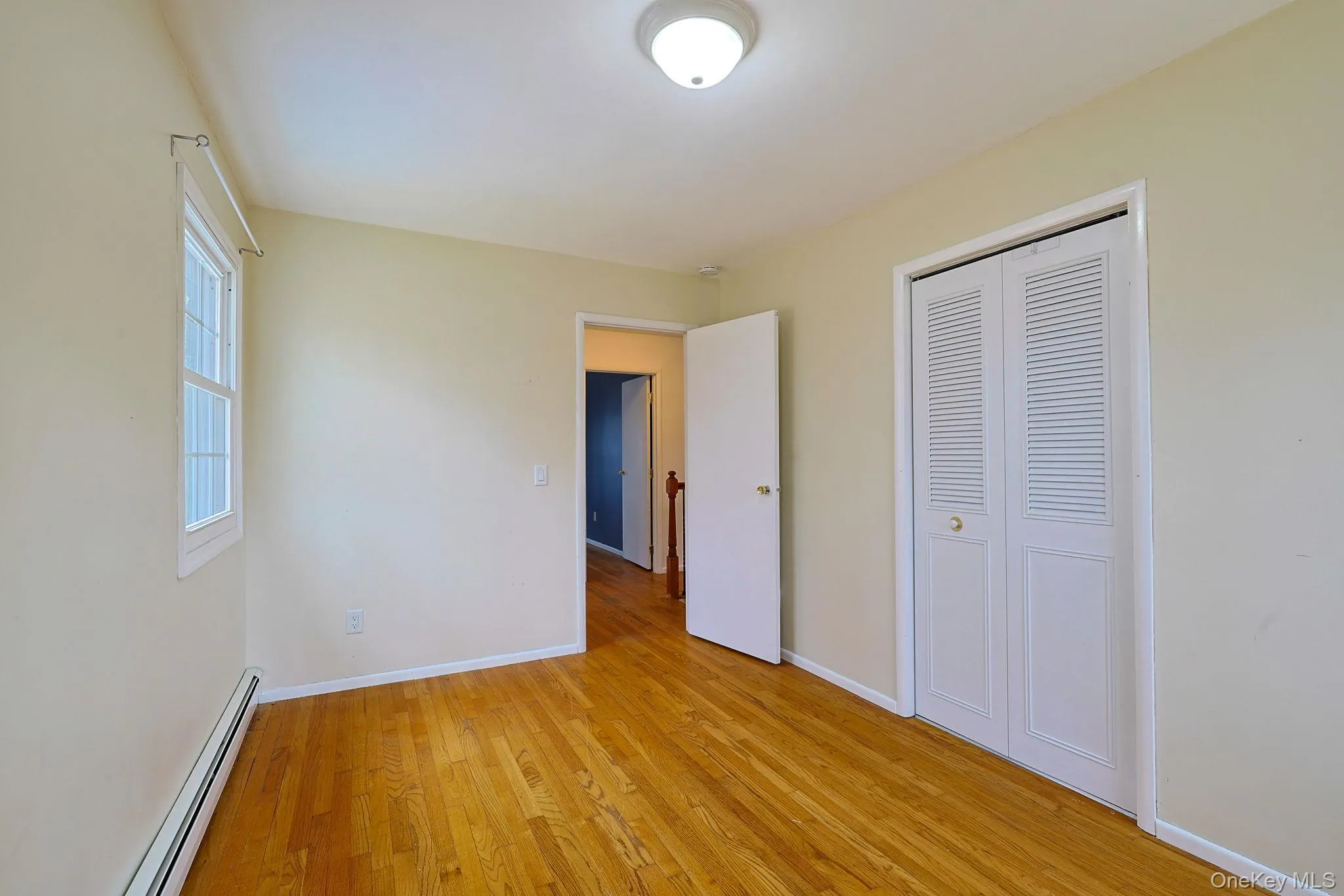 The property features hardwood floors, a window with natural light, and a closet with louvered bi-fold doors The property features hardwood floors, a window with natural light, and a closet with louvered bi-fold doors