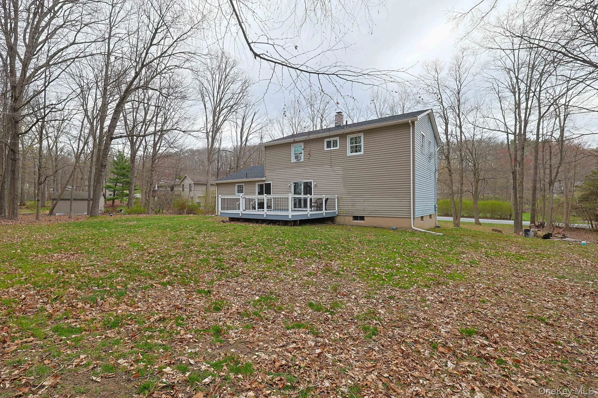 The property features an extensive lawn with mature trees and a rear deck The property features an extensive lawn with mature trees and a rear deck
