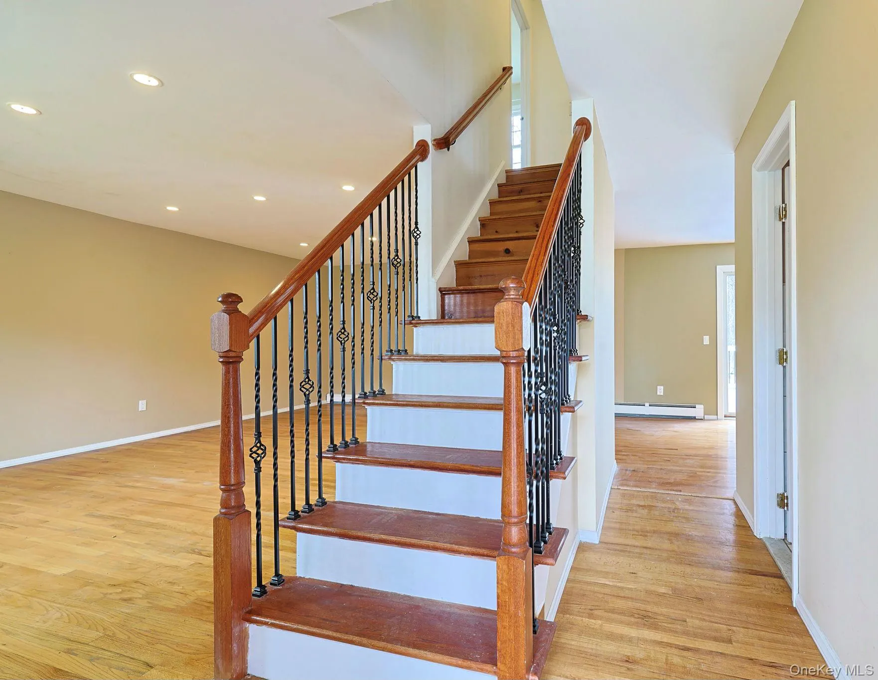 The property features a staircase with wooden treads and a decorative metal and wood railing The property features a staircase with wooden treads and a decorative metal and wood railing