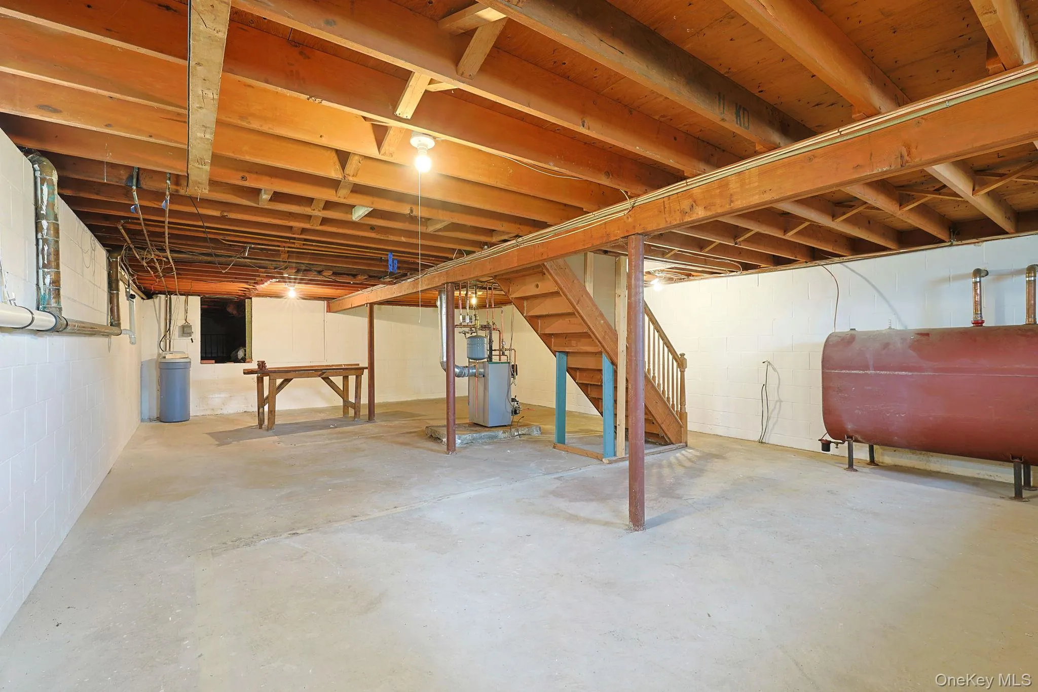 The property features an unfinished basement with exposed wooden beams, a concrete floor, and painted white walls The property features an unfinished basement with exposed wooden beams, a concrete floor, and painted white walls