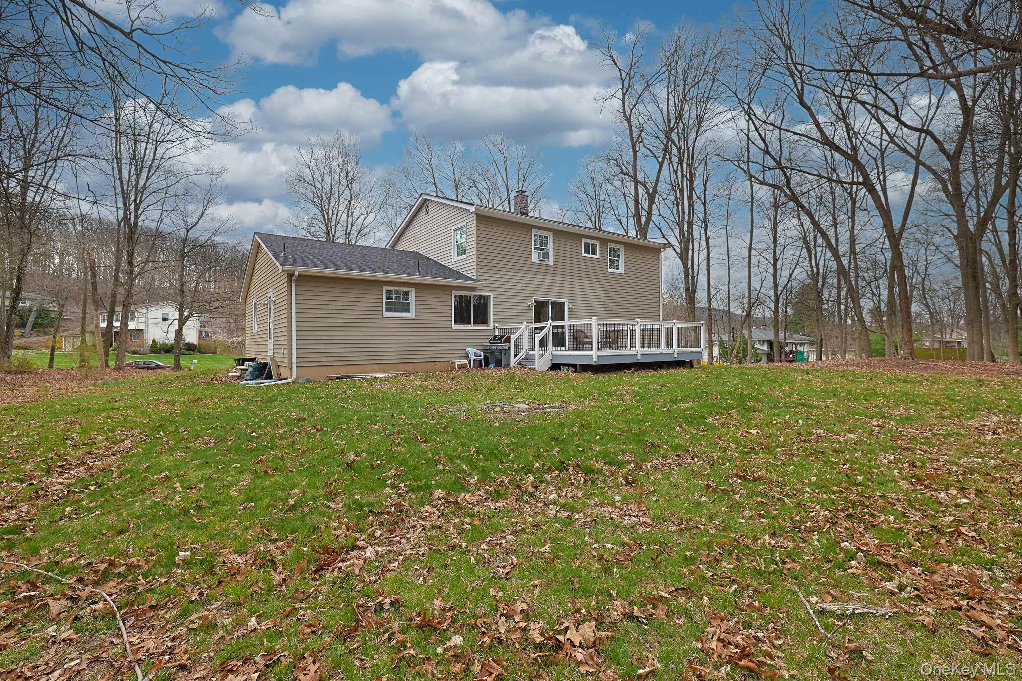 The property features a spacious yard with a green lawn and mature trees, offering a private setting The property features a spacious yard with a green lawn and mature trees, offering a private setting