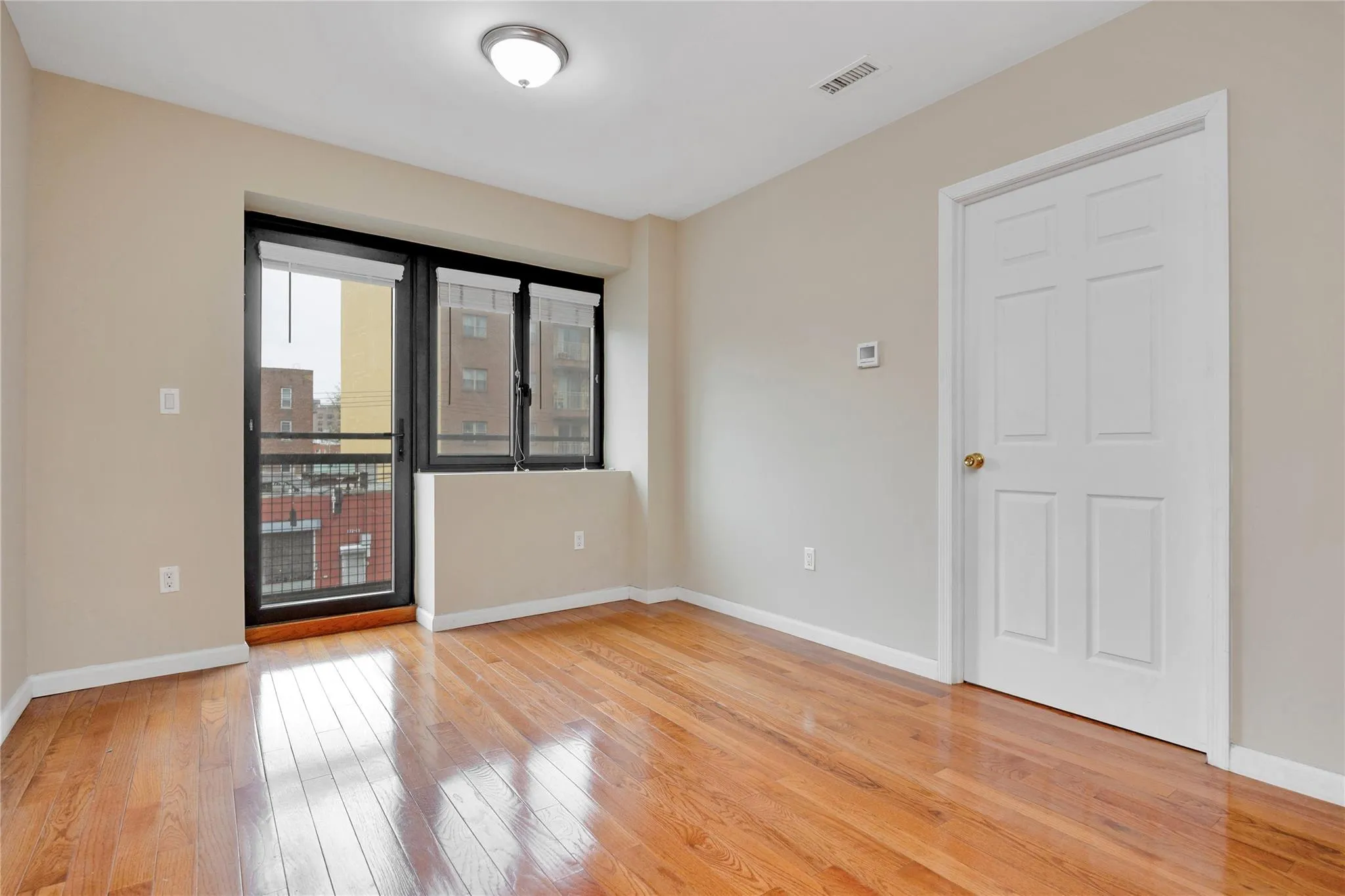 Empty room with visible vents, baseboards, and light wood-style floors Empty room with visible vents, baseboards, and light wood-style floors
