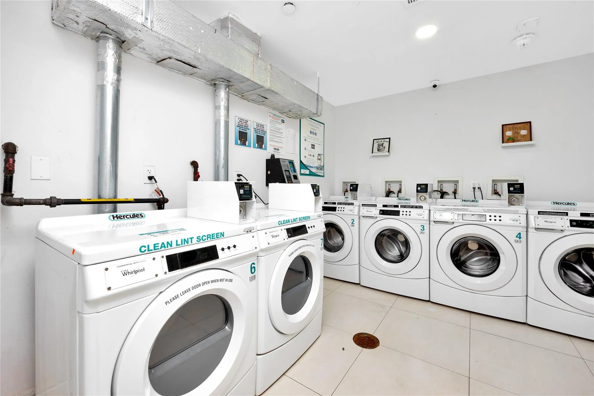 Shared laundry area with light tile patterned floors and independent washer and dryer Shared laundry area with light tile patterned floors and independent washer and dryer