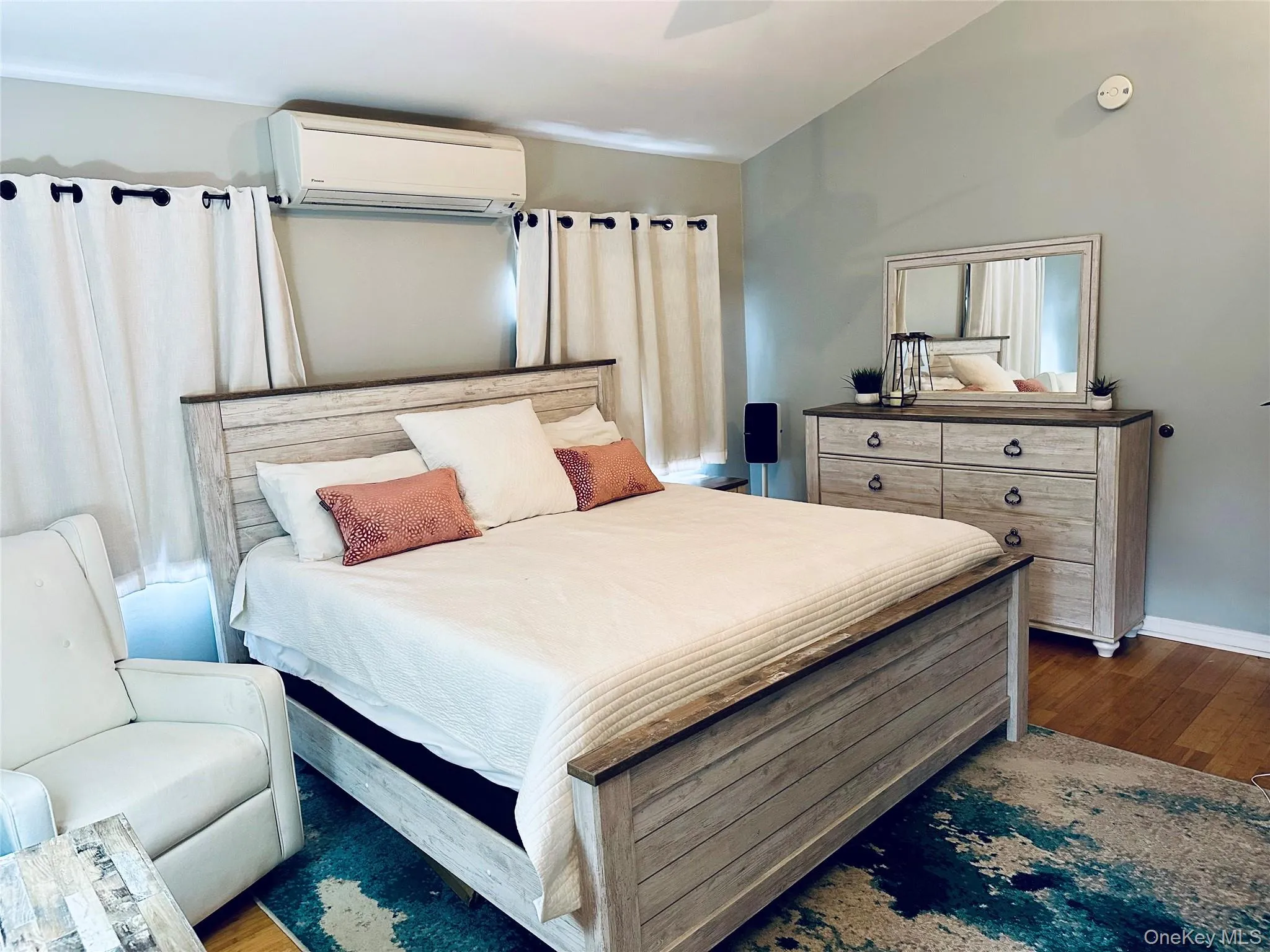 Bedroom featuring dark wood-style floors, baseboards, and a wall unit AC Bedroom featuring dark wood-style floors, baseboards, and a wall unit AC
