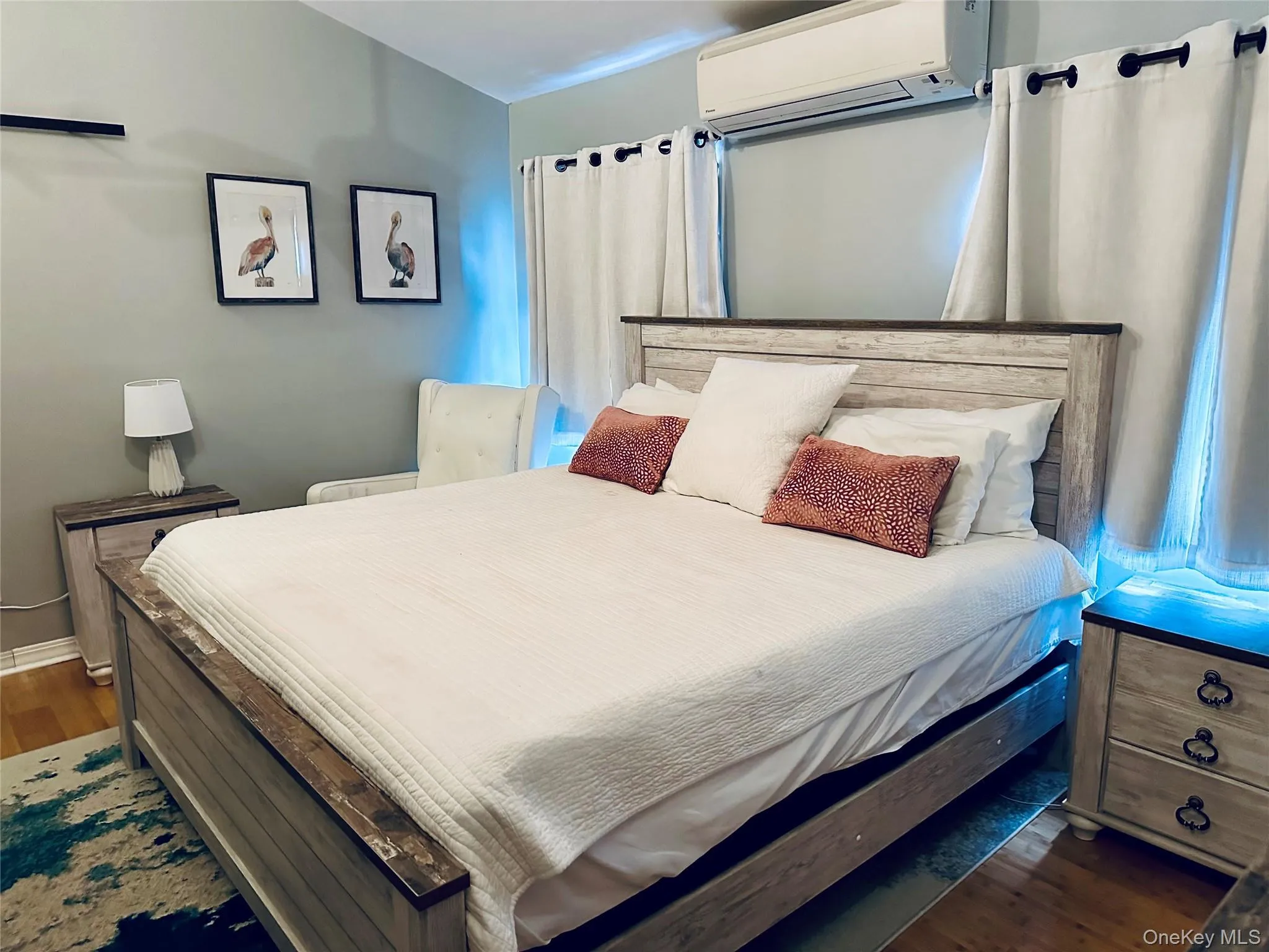 Bedroom featuring a wall unit AC and dark wood-style floors Bedroom featuring a wall unit AC and dark wood-style floors