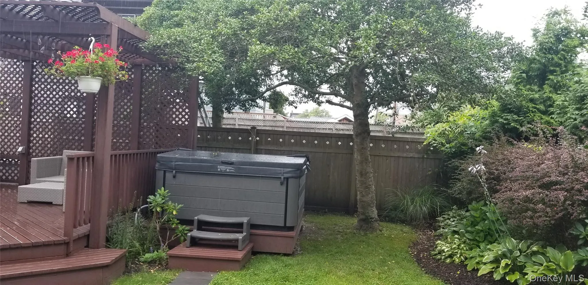 View of yard with a pergola, fence, a wooden deck, and a hot tub View of yard with a pergola, fence, a wooden deck, and a hot tub