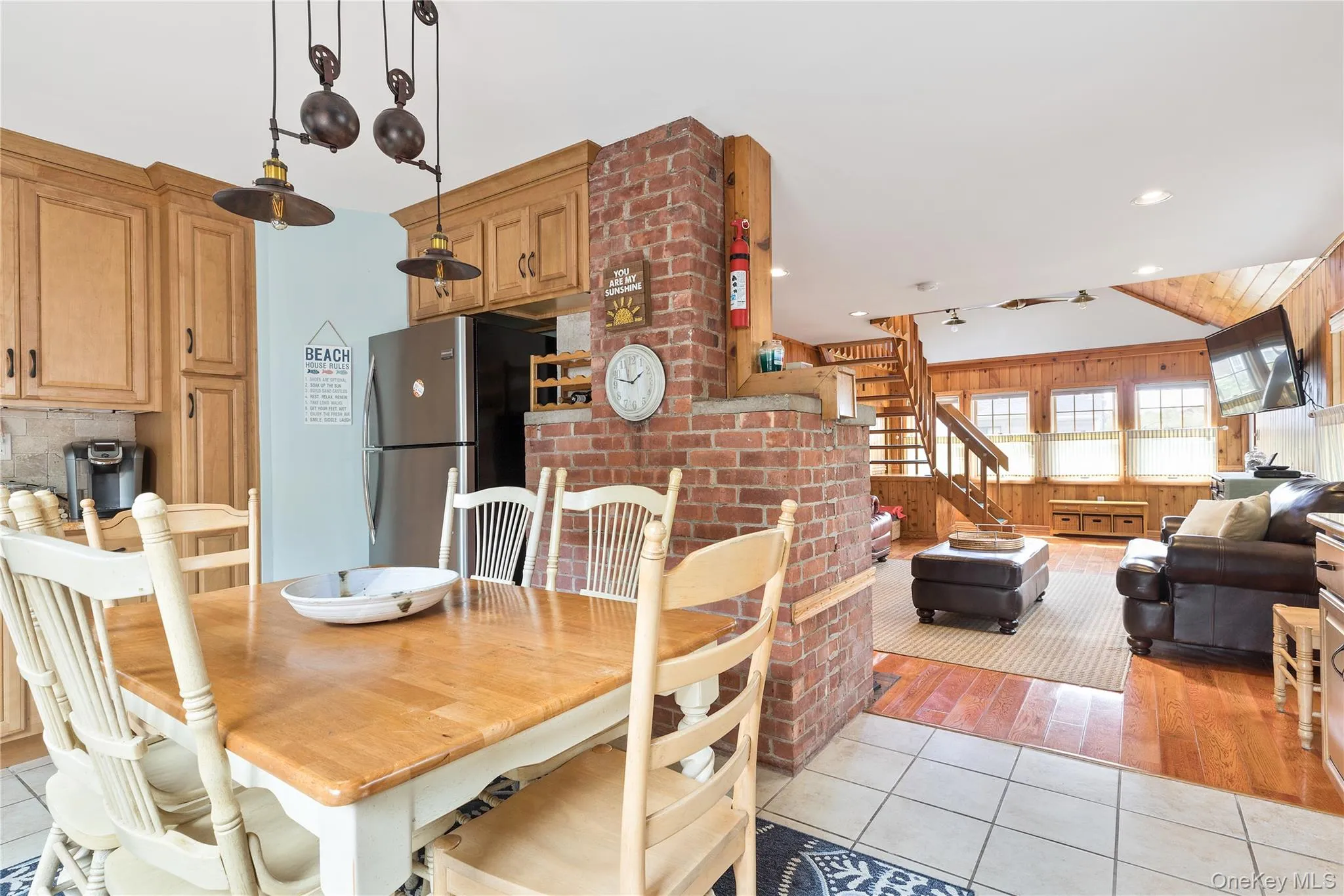Dining space with wood walls, recessed lighting, light tile patterned floors, and stairs Dining space with wood walls, recessed lighting, light tile patterned floors, and stairs