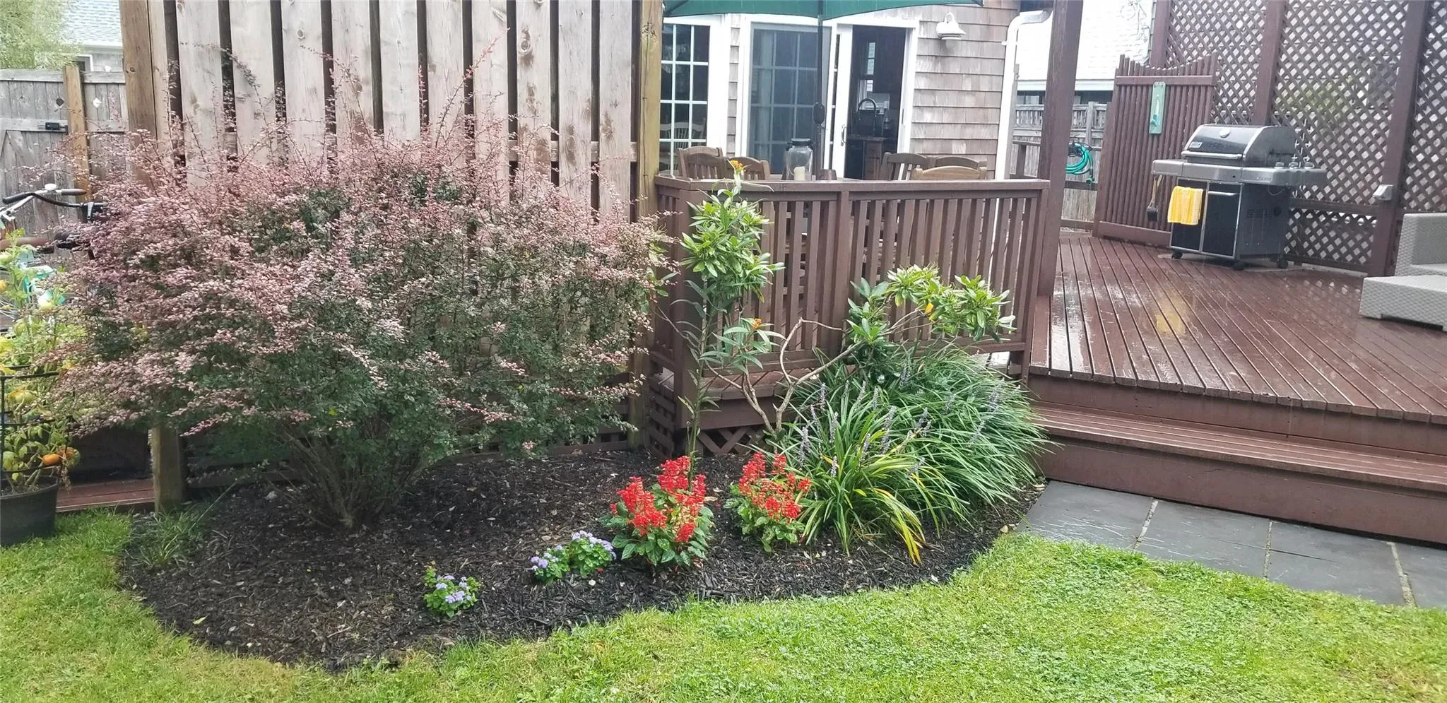 Wooden terrace with french doors, fence, and area for grilling Wooden terrace with french doors, fence, and area for grilling