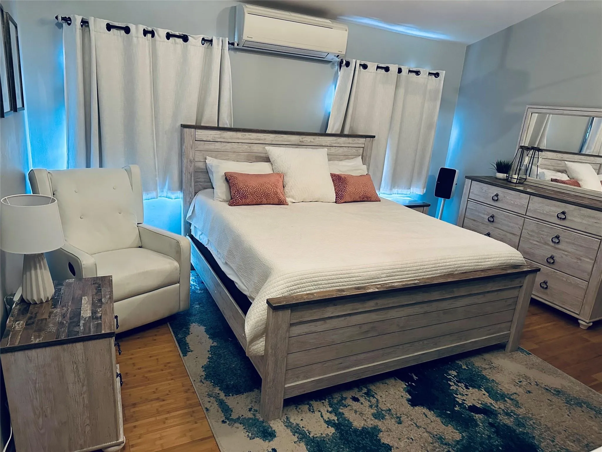 Bedroom featuring an AC wall unit and dark wood-style flooring Bedroom featuring an AC wall unit and dark wood-style flooring