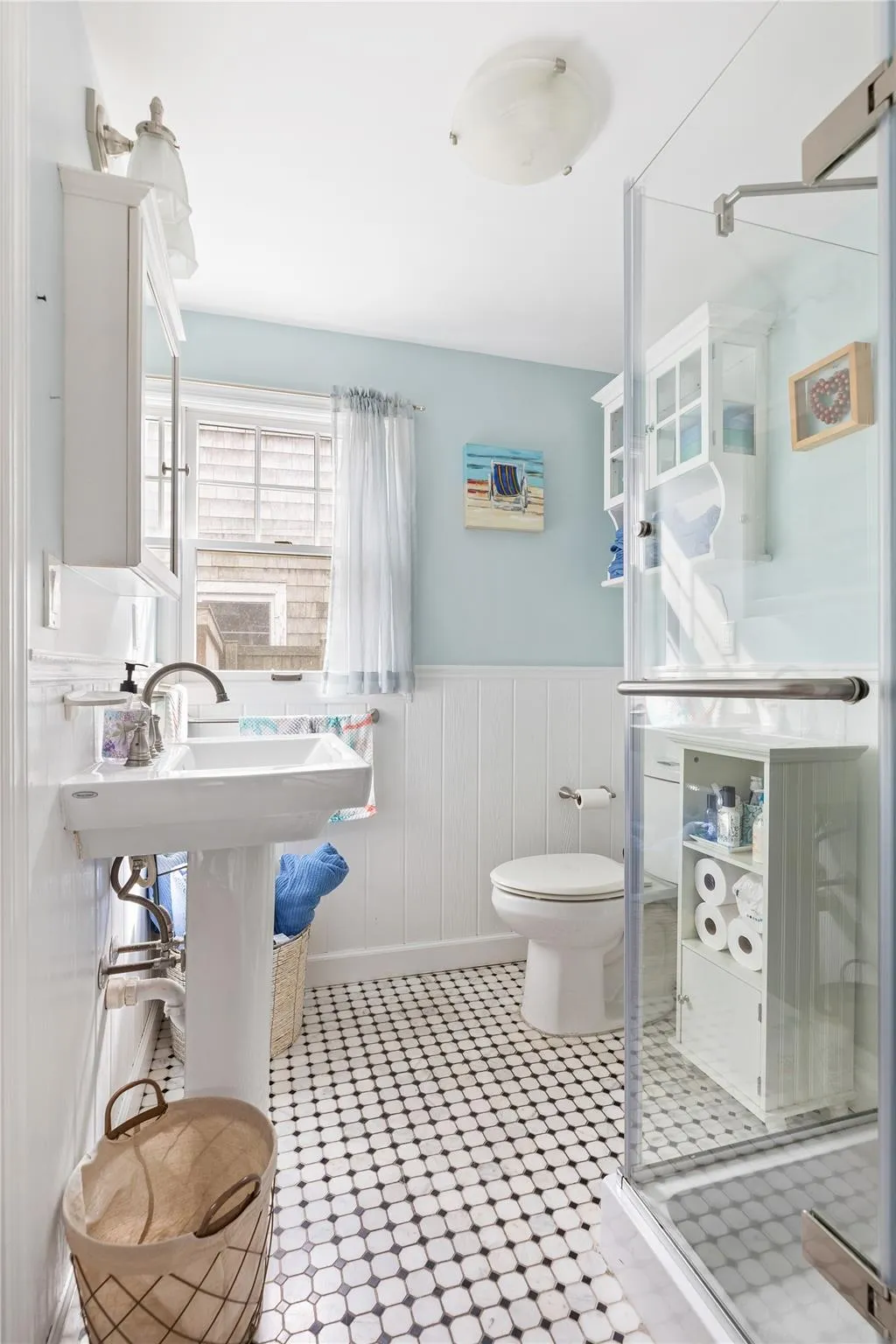 Bathroom featuring toilet, a stall shower, wainscoting, and tile patterned floors Bathroom featuring toilet, a stall shower, wainscoting, and tile patterned floors
