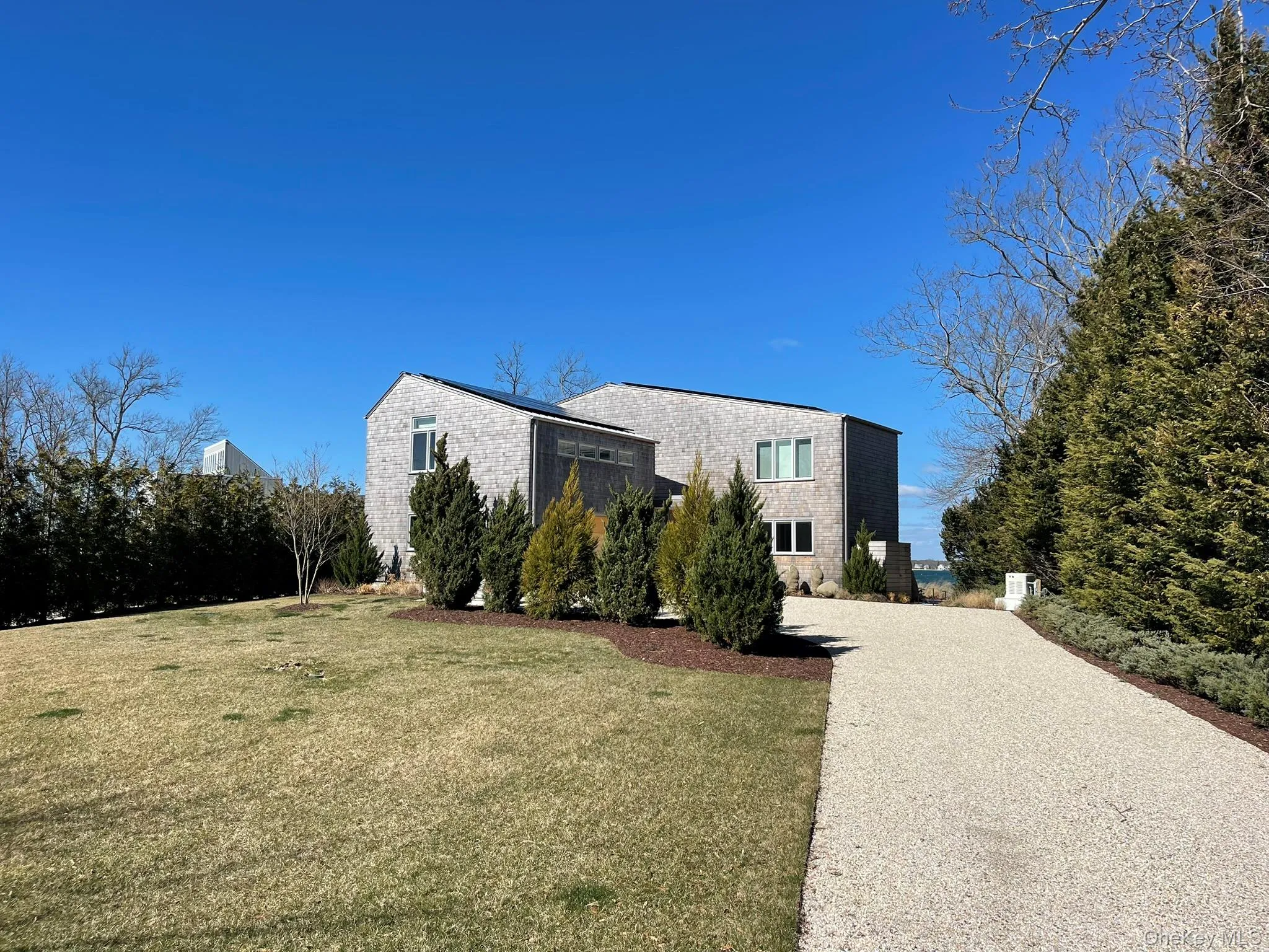 View of property exterior with a lawn and gravel driveway View of property exterior with a lawn and gravel driveway