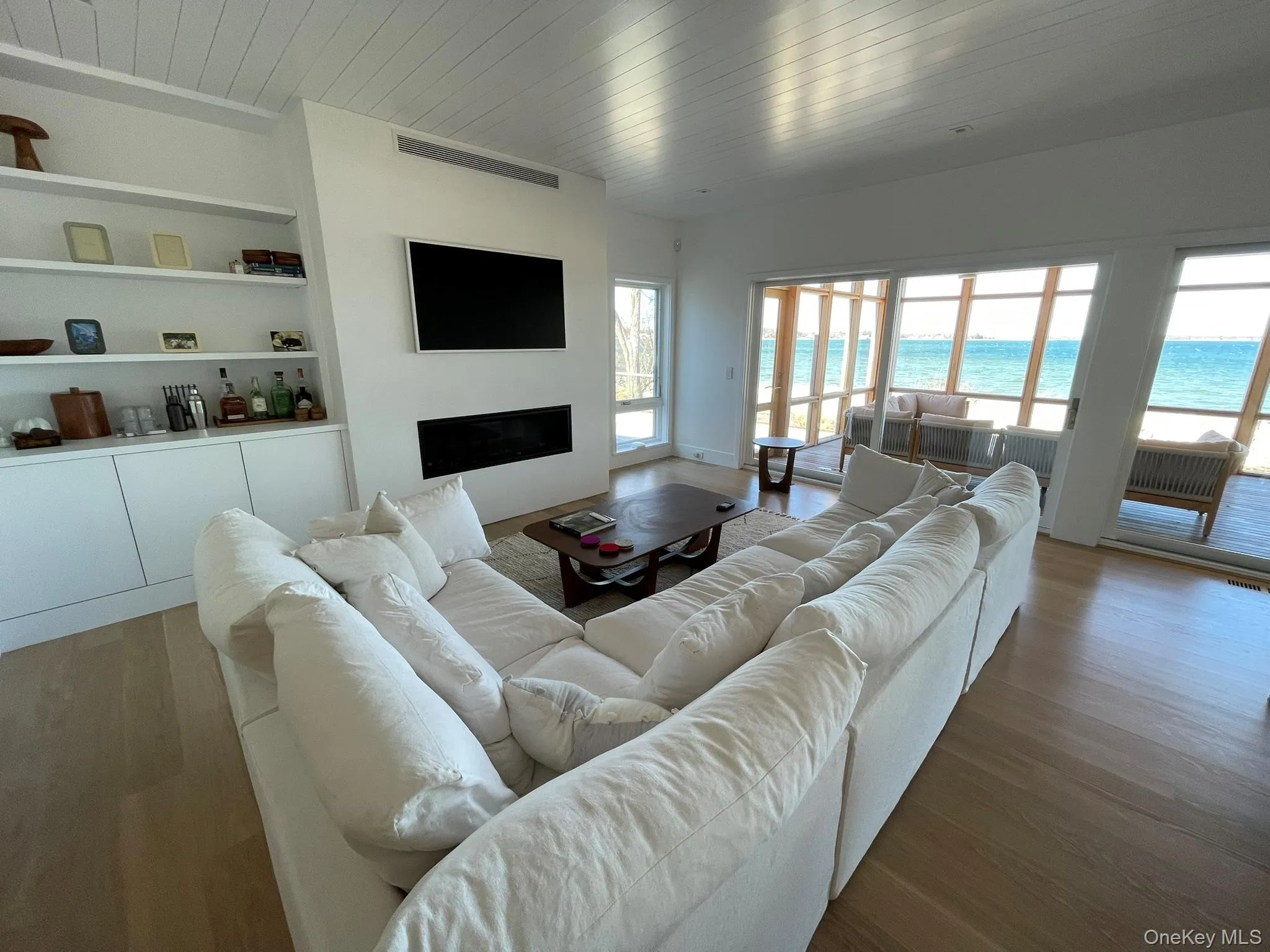 Living room featuring wood ceiling, a fireplace, and plenty of natural light Living room featuring wood ceiling, a fireplace, and plenty of natural light