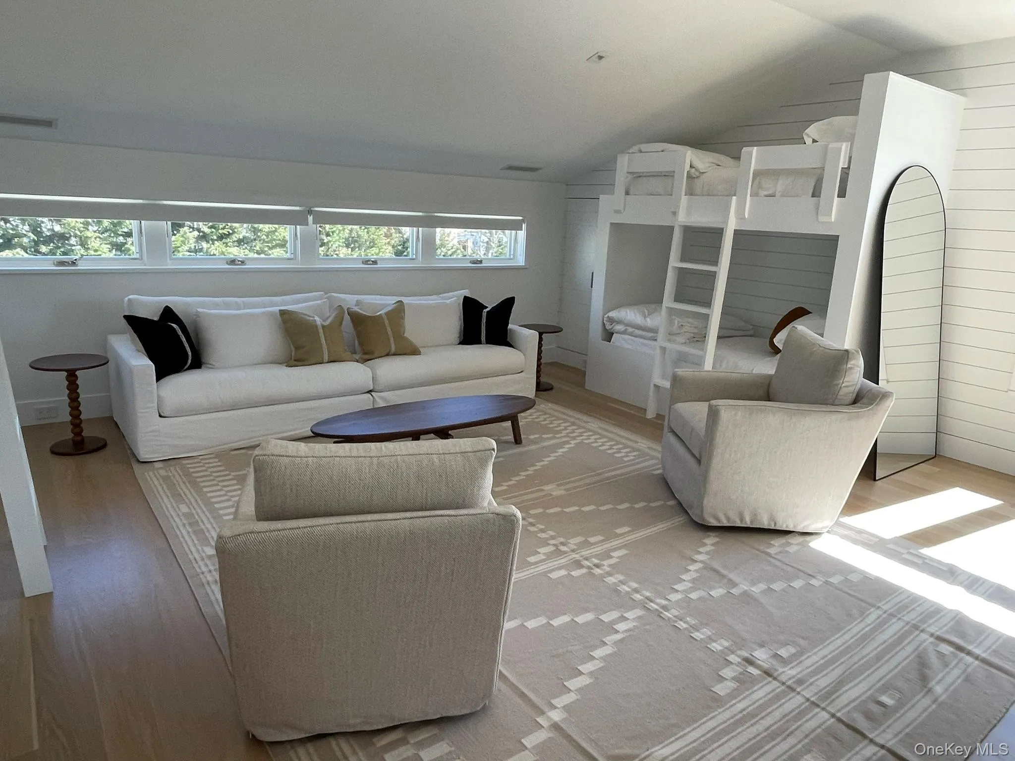 Living room with light wood-style flooring, visible vents, and vaulted ceiling Living room with light wood-style flooring, visible vents, and vaulted ceiling