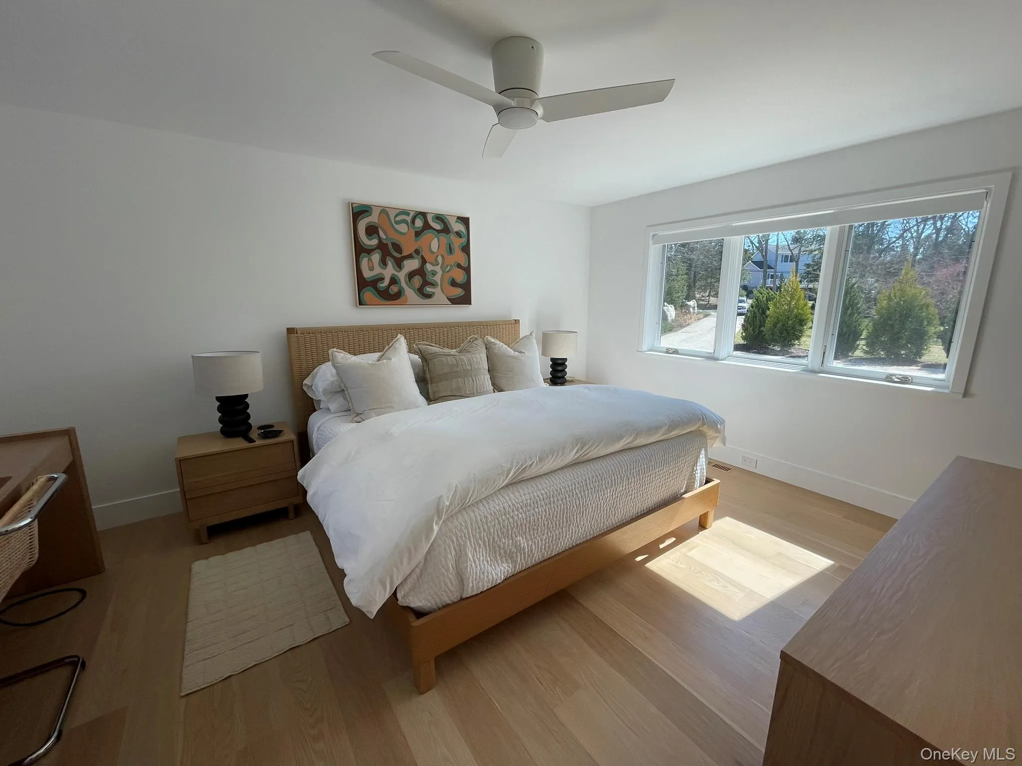 Bedroom with light wood-style flooring, baseboards, and a ceiling fan Bedroom with light wood-style flooring, baseboards, and a ceiling fan